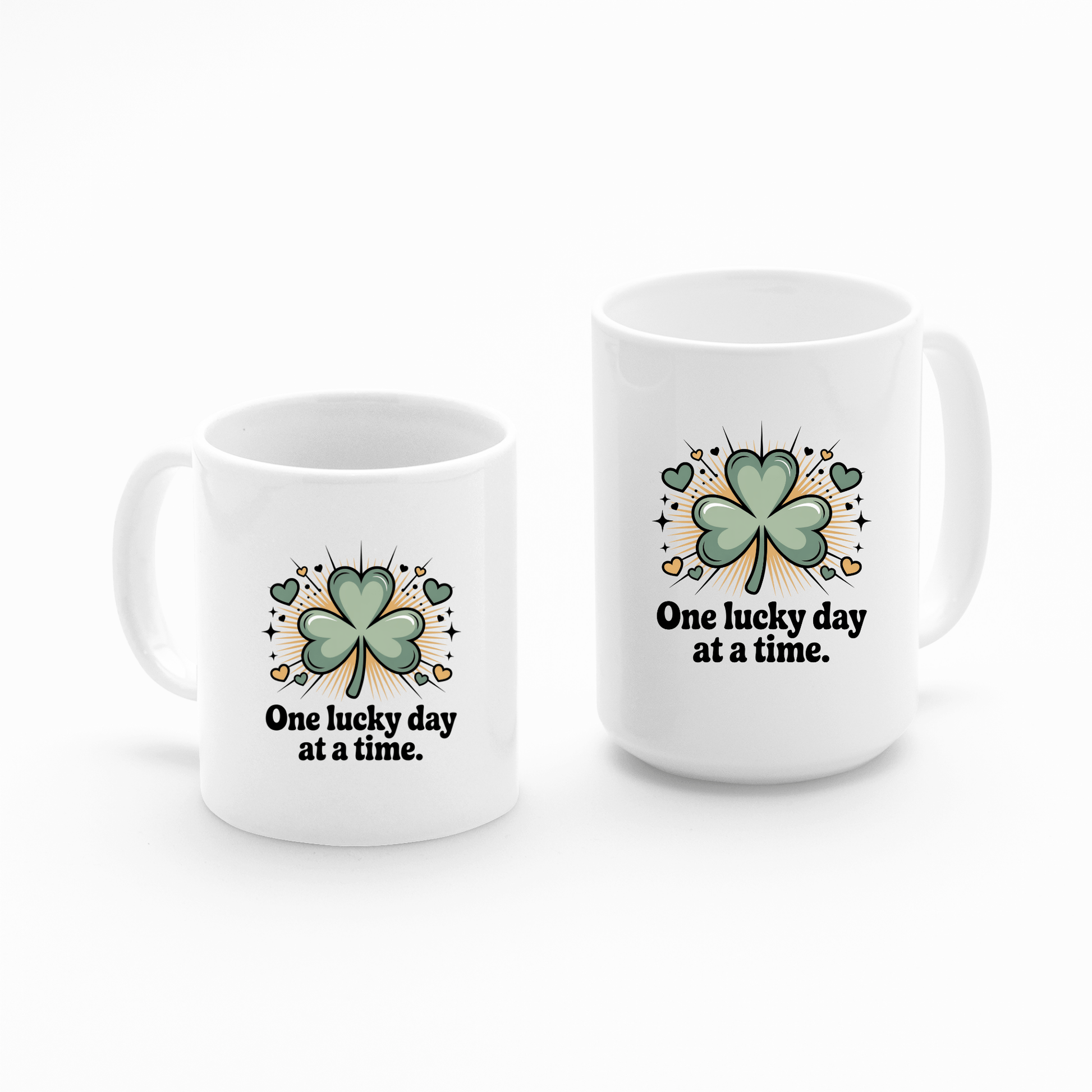 The Mirabilia Boutique "One Lucky Day at a Time Mug – Shamrock Ceramic Cup" features white ceramic, green four-leaf clovers, the uplifting phrase, and is decorated with hearts, stars, and gold coins on each mug.