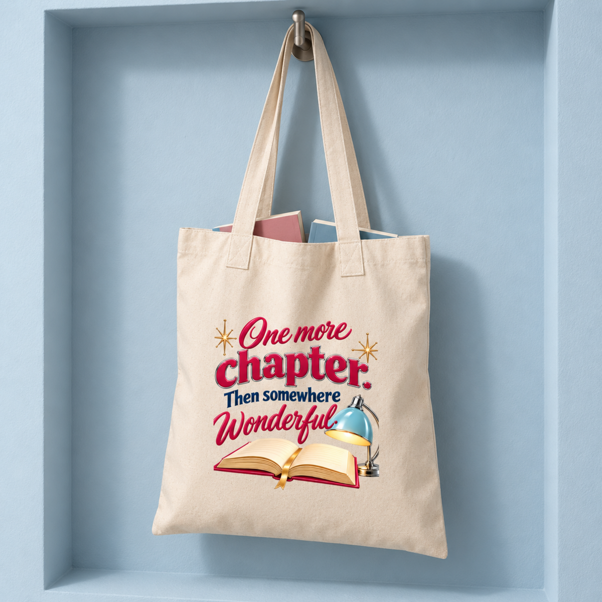 One More Chapter Book Lover Tote | Chrome & Starlight canvas reading tote featuring a printed design of an open book and desk lamp with the text “One more chapter. Then somewhere Wonderful.”.