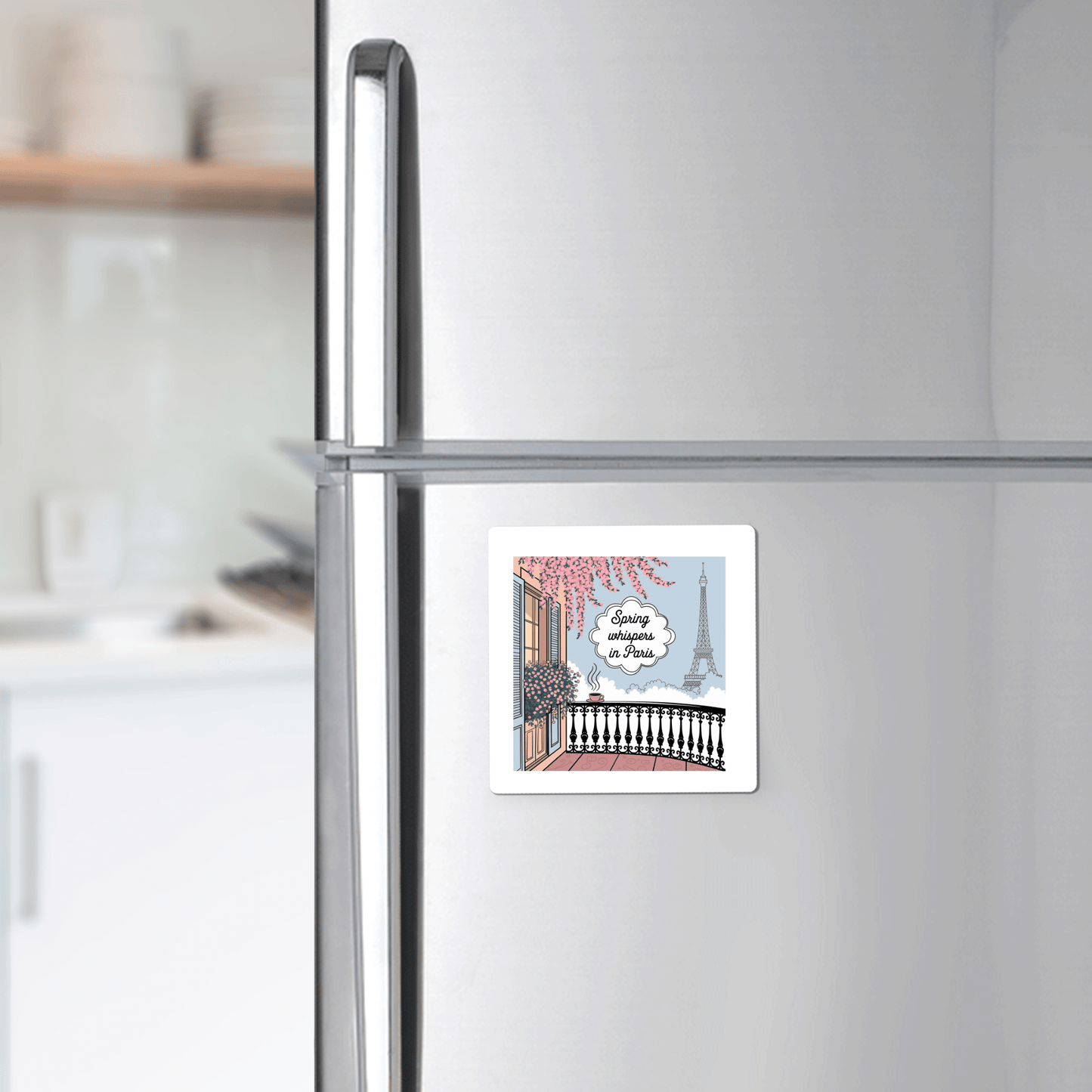 The Spring Whispers in Paris Magnet – Eiffel Tower View by Mirabilia Boutique features an illustrated Parisian balcony and the Eiffel Tower, with "Living in Paris" over a serene spring morning scene, perfect for your stainless steel refrigerator.