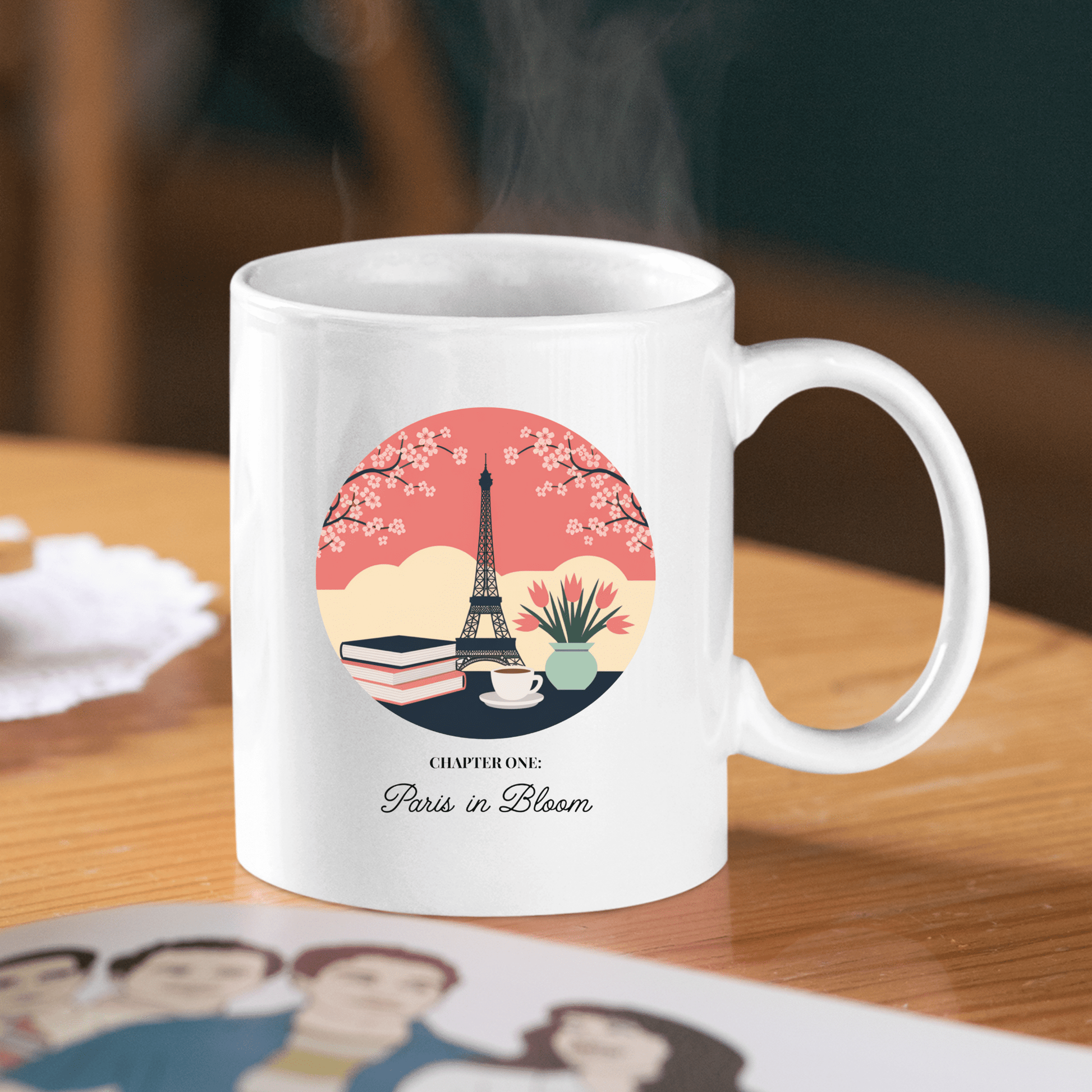 The Mirabilia Boutique Paris Book Lover Mug – Chapter One: Paris in Bloom features a white design with the Eiffel Tower, cherry blossoms, a book, and a cup. Perfect for book lovers and cherry blossom fans.