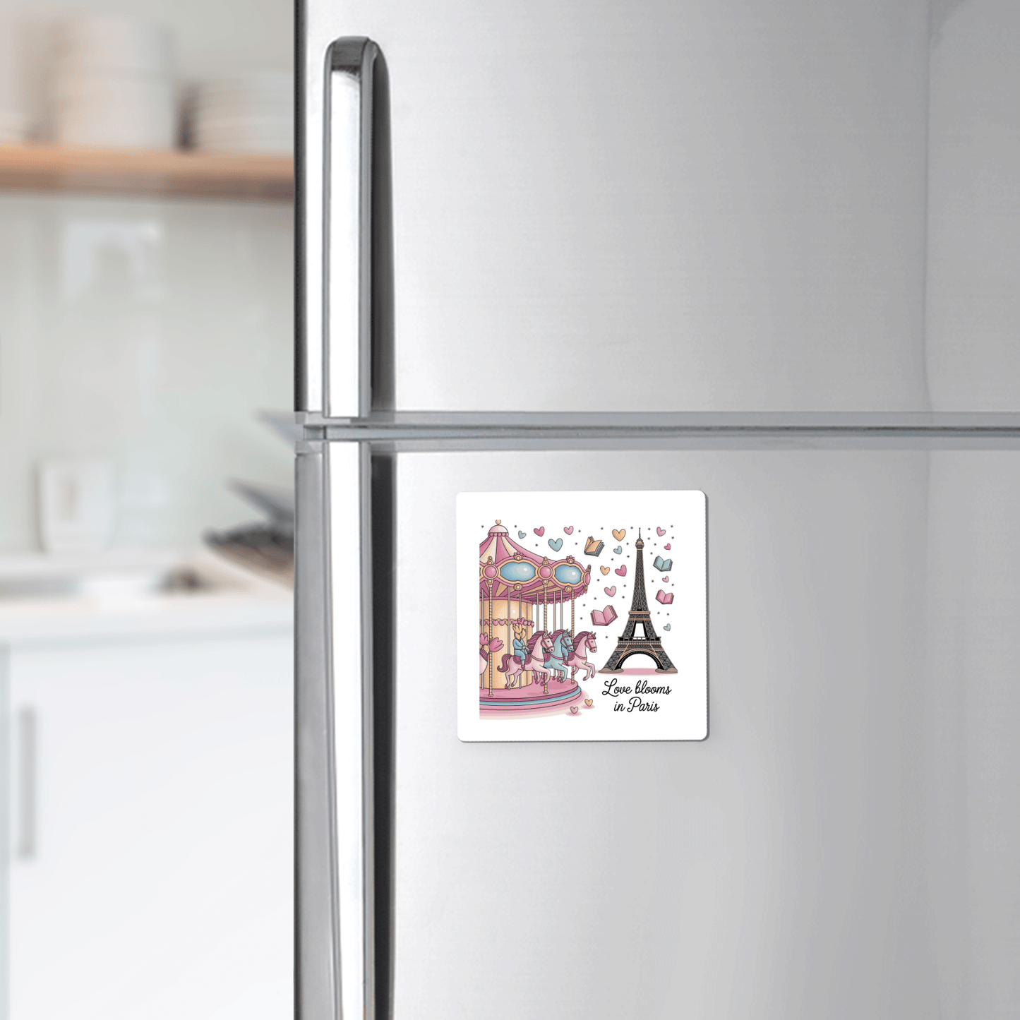A modern kitchen with white cabinets features a Mirabilia Boutique "Love Blooms in Paris Magnet – Whimsy & Romance," displaying a carousel, the Eiffel Tower, and the phrase “Love blooms in Paris.”.