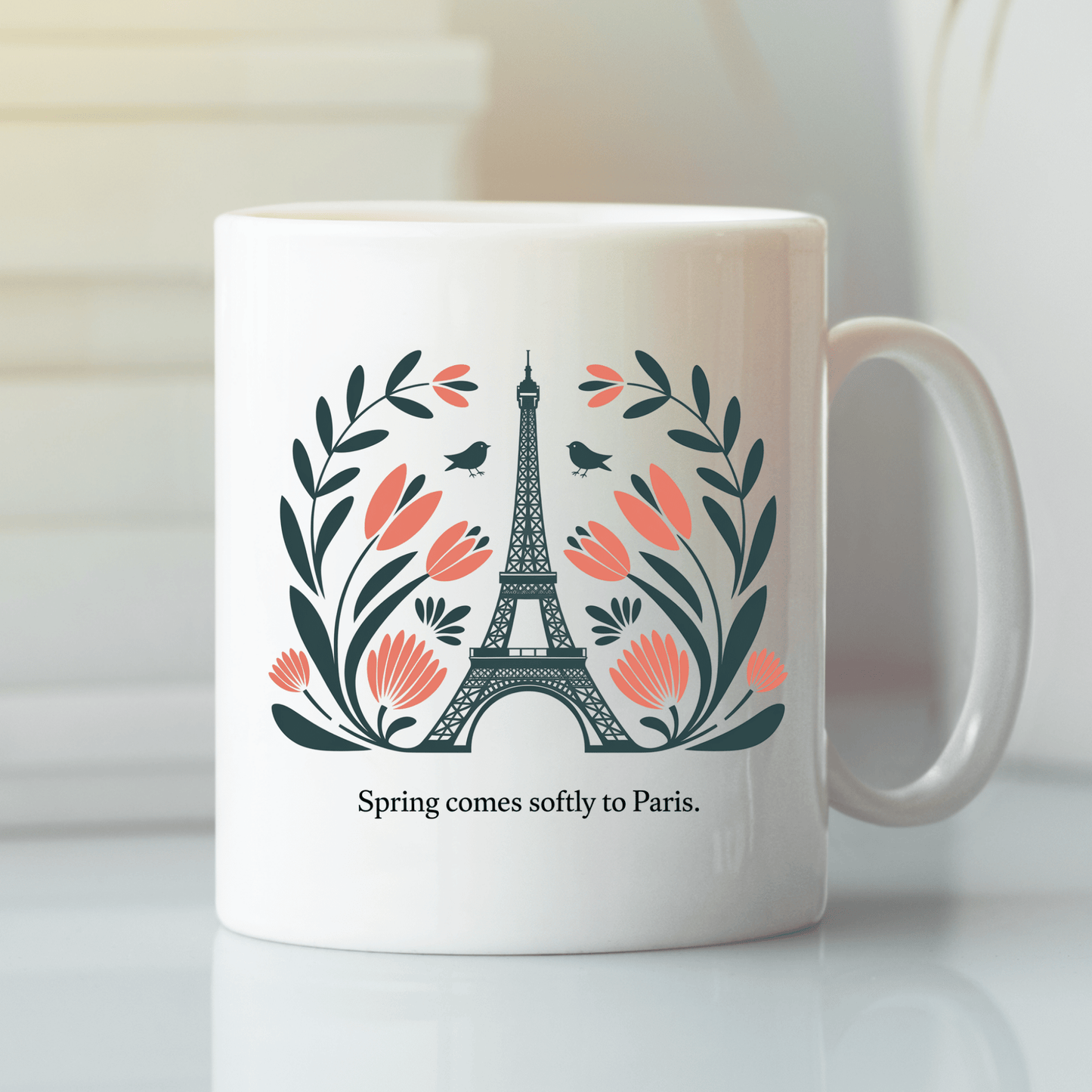 The Paris Spring Mug – Eiffel Tower & Floral Design by Mirabilia Boutique features the iconic tower with pink flowers, leaves, two small birds, and the phrase "Spring comes softly to Paris.