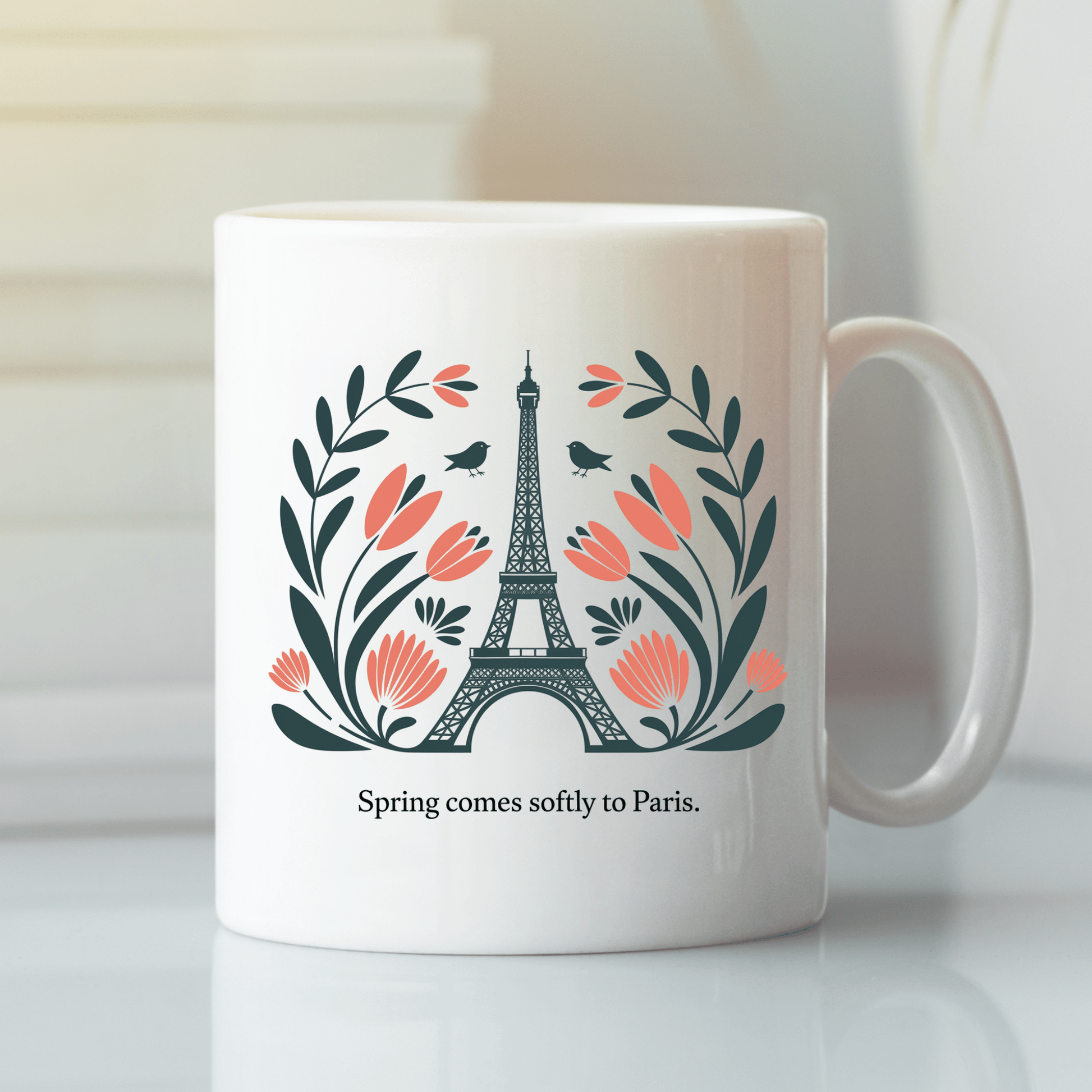 The Paris Spring Mug – Eiffel Tower & Floral Design by Mirabilia Boutique features the iconic tower with pink flowers, leaves, two small birds, and the phrase "Spring comes softly to Paris.