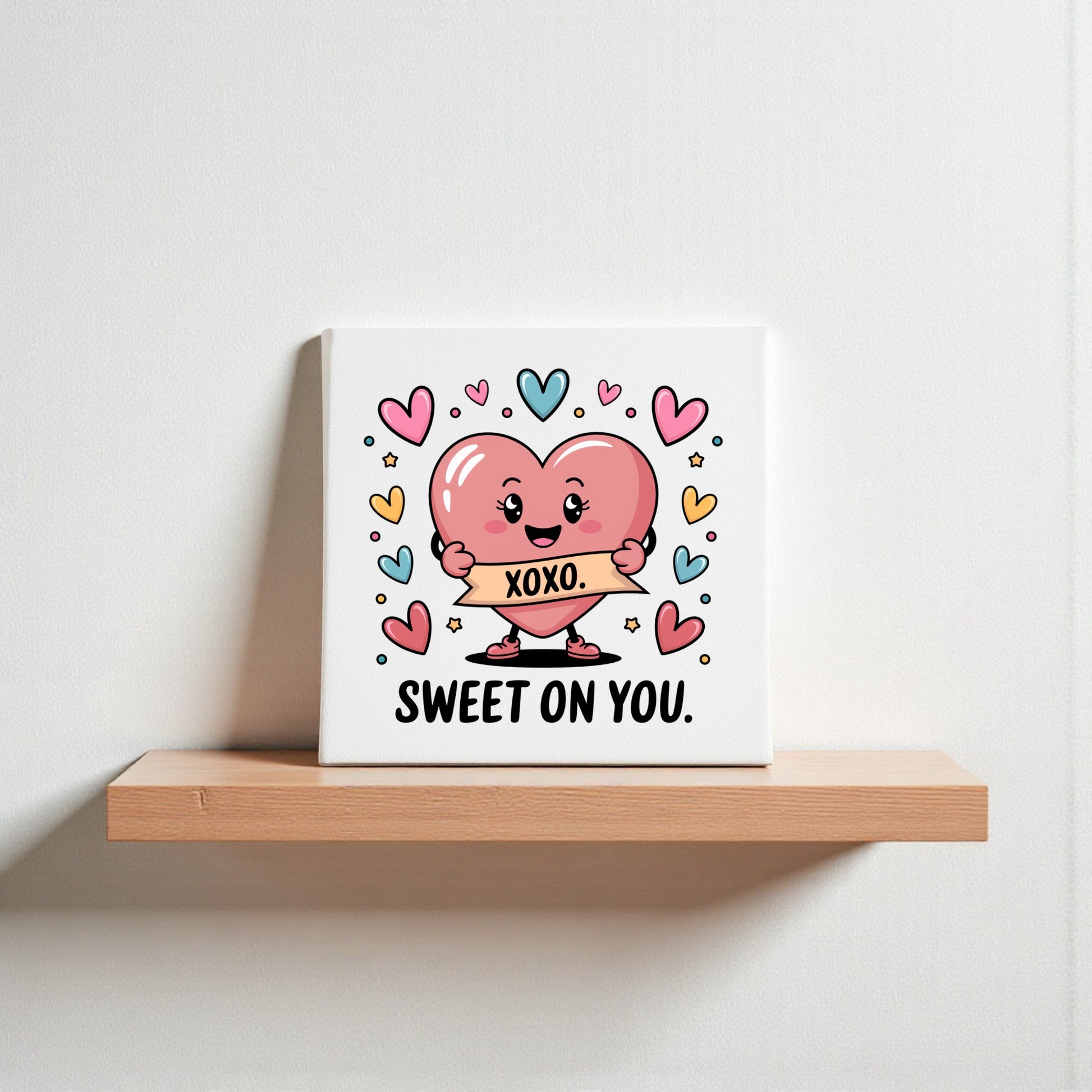 The Mirabilia Boutique “Sweet On You XOXO Valentine Canvas” features a cute cartoon heart with a "XOXO." sign, surrounded by colorful hearts. Ideal for Valentine’s décor or nursery art; “SWEET ON YOU” text appears below on a white background.