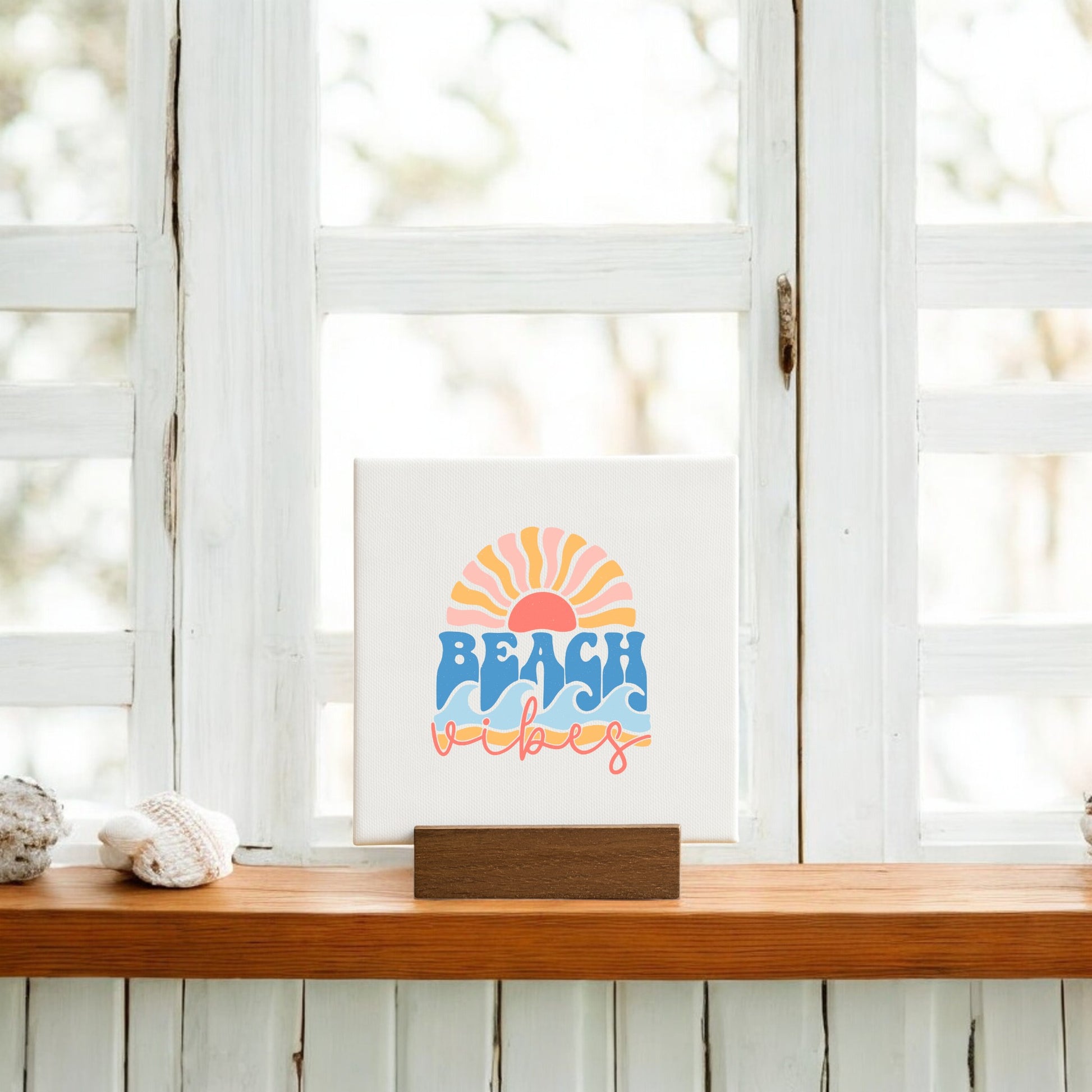 The Beach Vibes Mini Canvas – Retro Summer Desk Art by Mirabilia Boutique features a sunset, waves, and "BEACH vibes" in colorful letters on a wooden stand—ideal for beach decor or a cheerful summer gift.