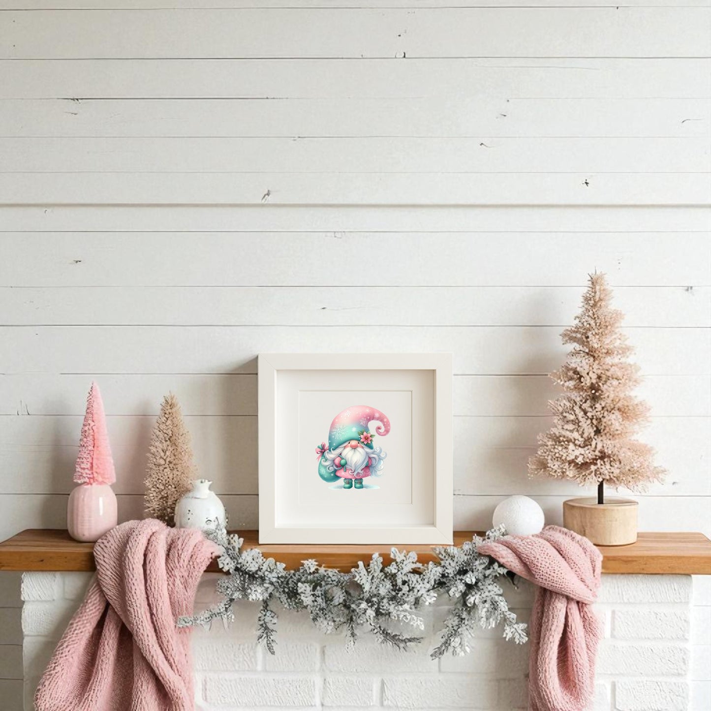 A cozy mantel is adorned with Mirabilia Boutique’s pastel gnome wall art (teal hat), pink and white mini trees, a white vase, pink garland, and a draped soft pink blanket—perfect winter charm with Scandinavian flair.