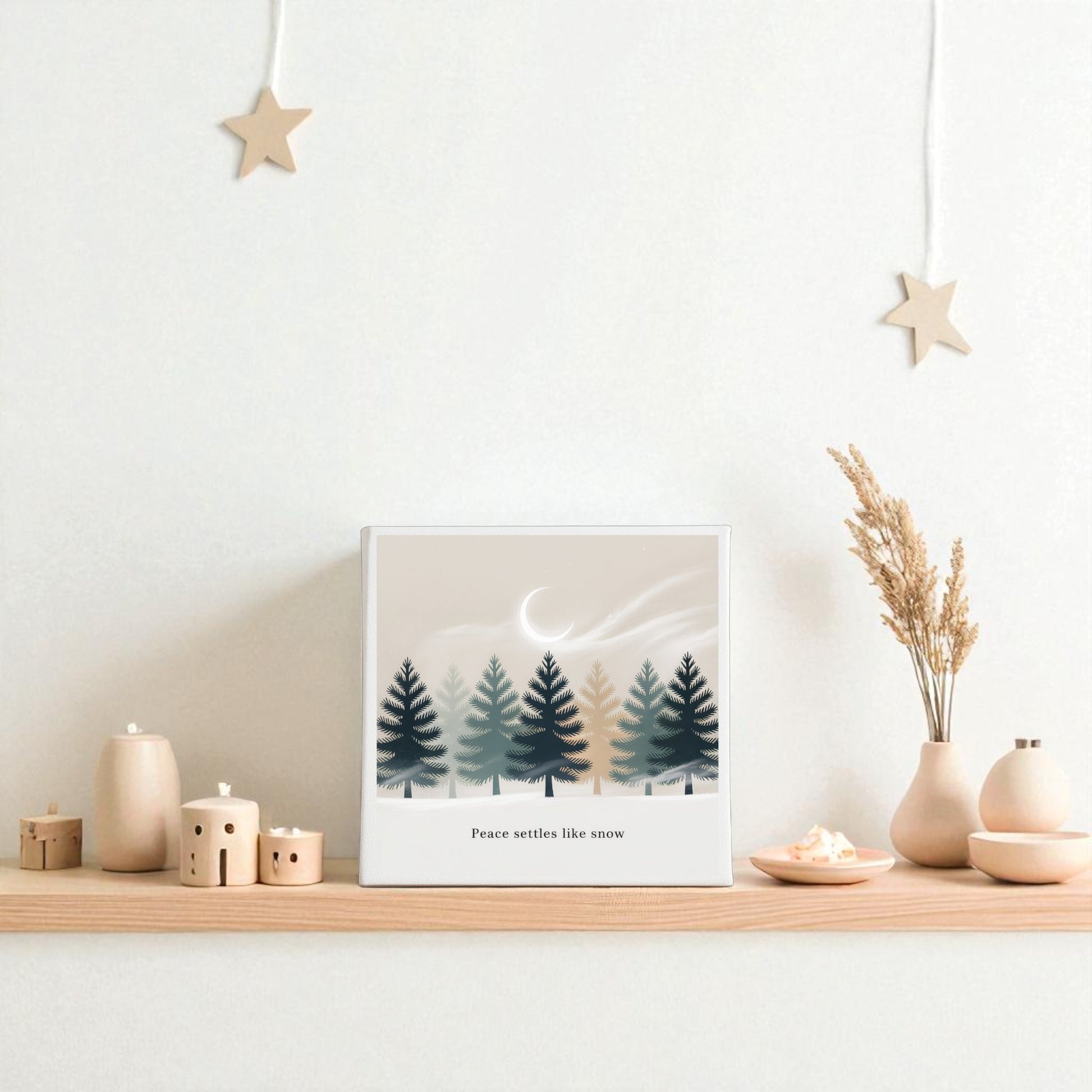 The Peace Settles Like Snow Canvas by Mirabilia Boutique is a winter minimalist wall art, perfect for serene nursery decor when paired with ceramic houses, neutral vases, dried flowers, and star ornaments.