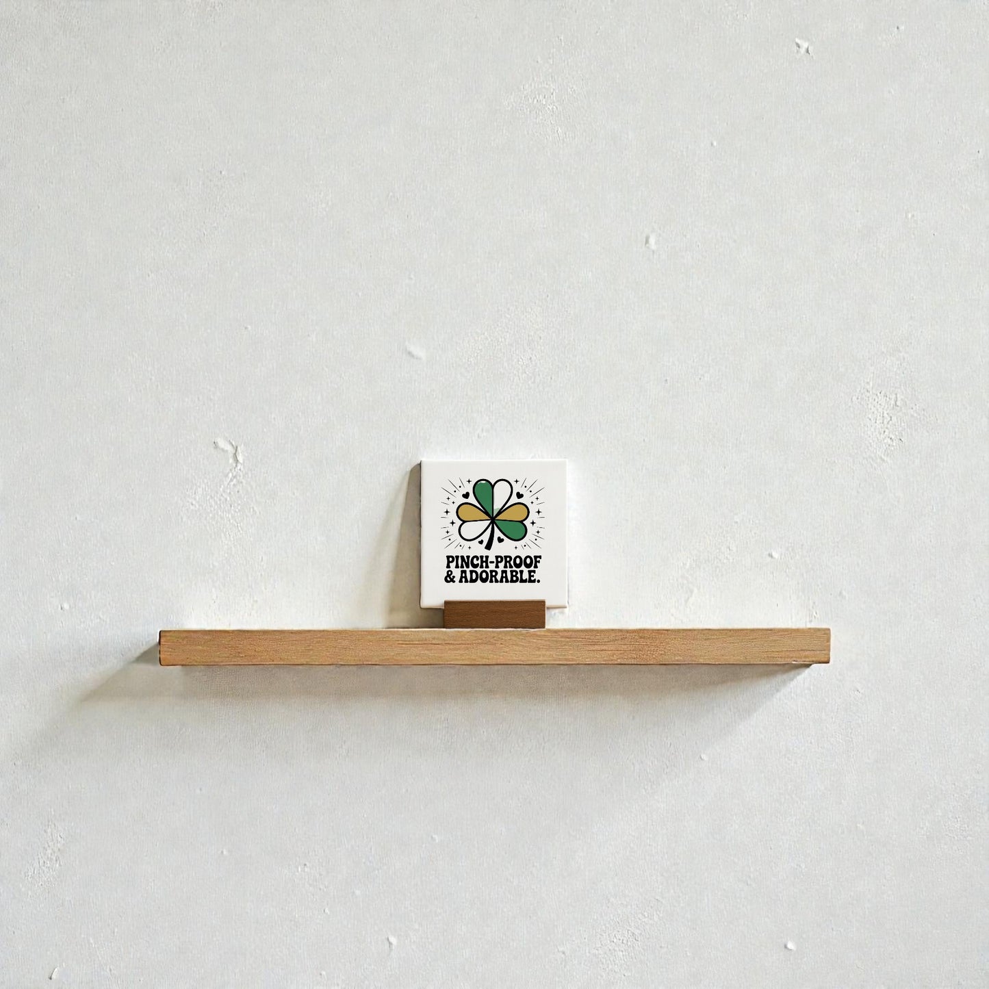 A small wooden shelf displays the Mirabilia Boutique Pinch-Proof & Adorable Canvas Sign (4x4), featuring a green shamrock and festive text—an adorable St. Patrick’s Day decor accent for any kids room.