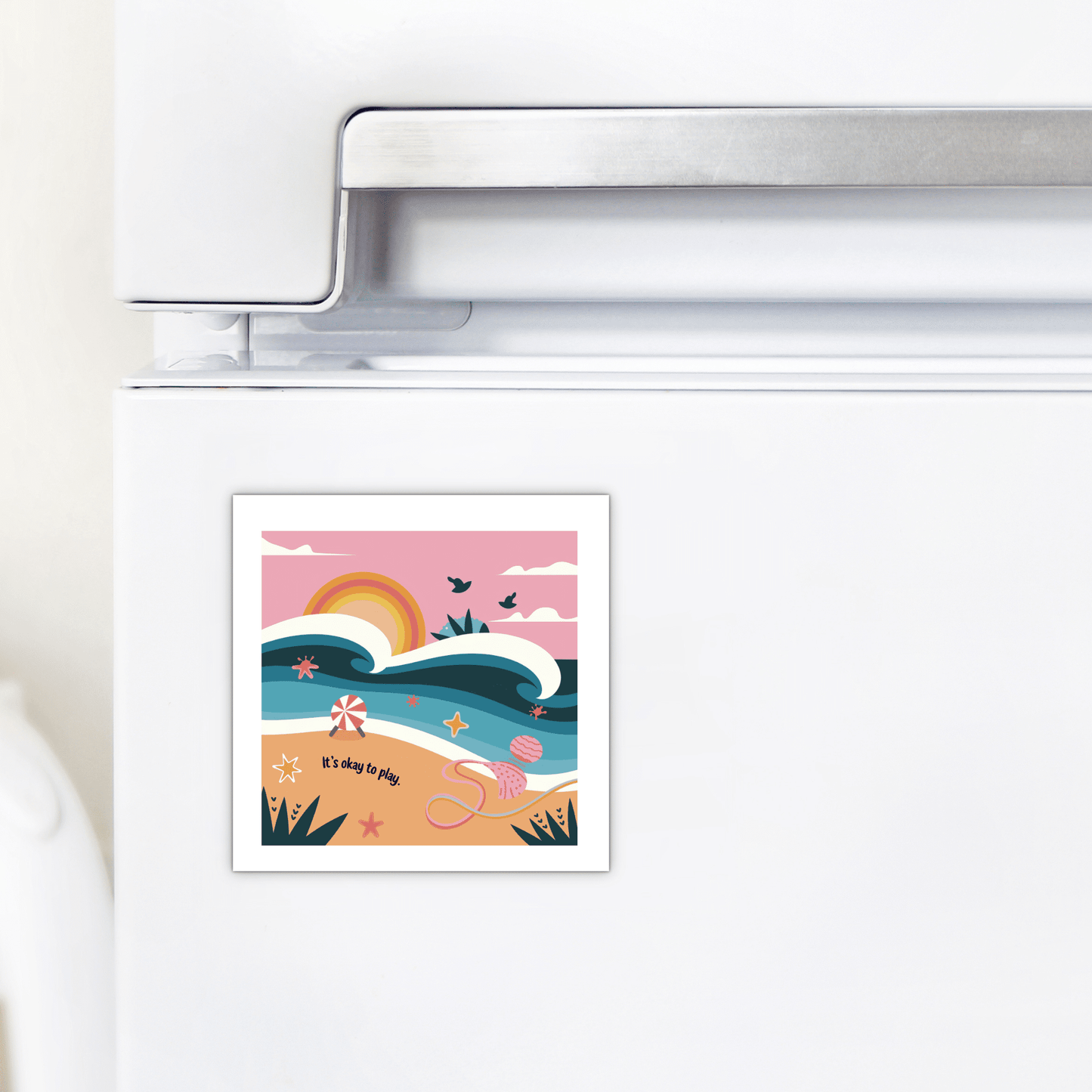 The Mirabilia Boutique It’s Okay to Play Magnet – Whimsical Ocean Joy features a vibrant beach scene with waves, sunrise, birds, starfish, seashells, and toys. The playful text on the fridge magnet reads: "It's okay to play.