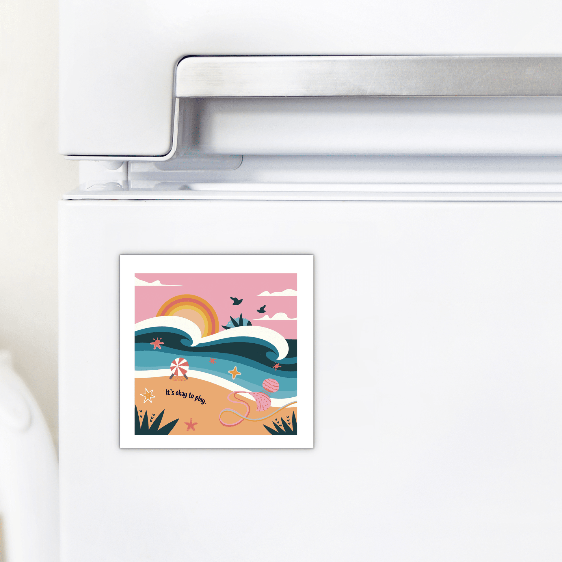 The Mirabilia Boutique It’s Okay to Play Magnet – Whimsical Ocean Joy features a vibrant beach scene with waves, sunrise, birds, starfish, seashells, and toys. The playful text on the fridge magnet reads: "It's okay to play.