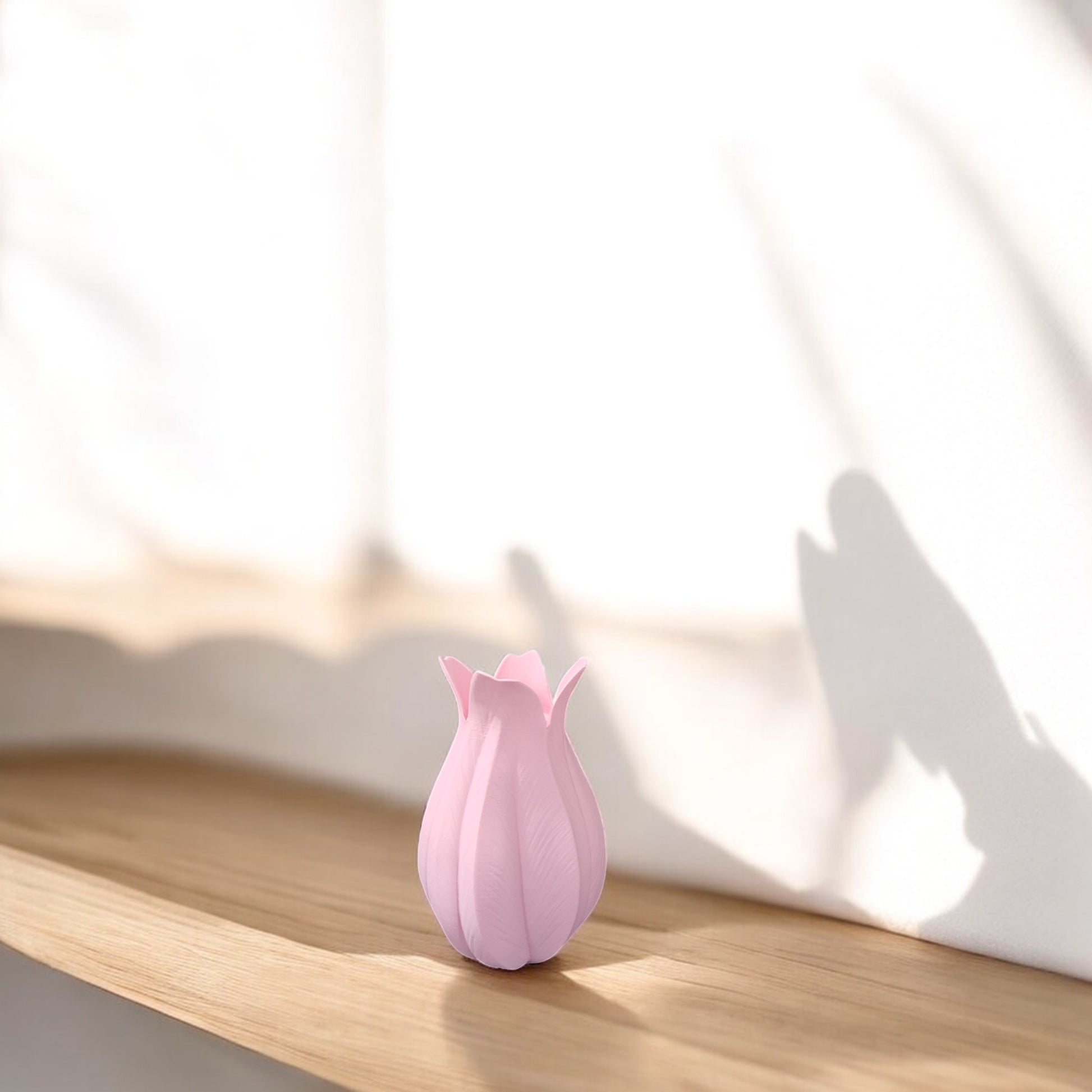 The Pink Tulip Vase by Mirabilia Boutique sits on a light wooden shelf, bathed in natural light and soft shadows—an ideal decorative accent for Easter or Mother’s Day on a white background.