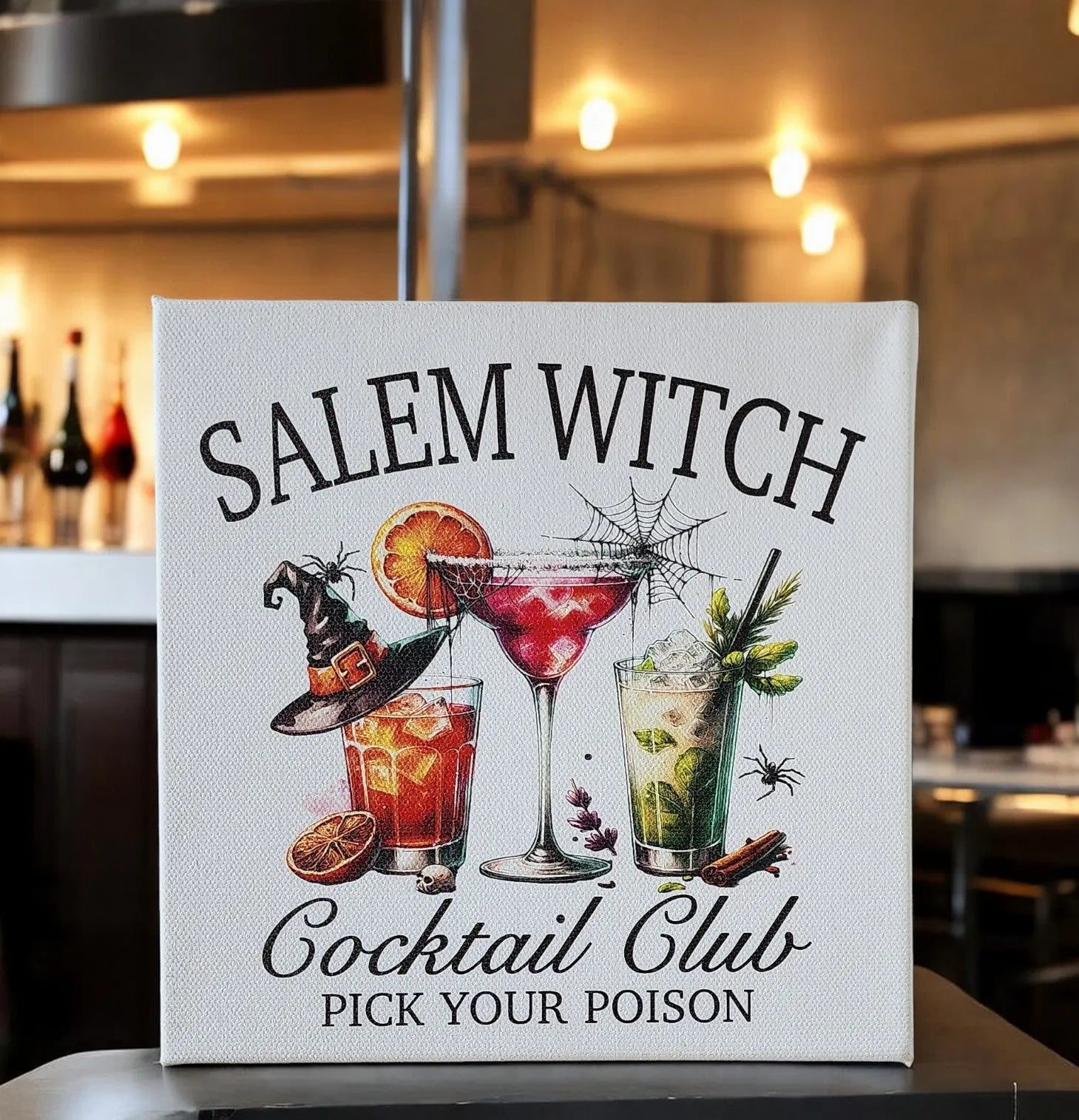 The Mirabilia Boutique Salem Witch Cocktail Club Halloween Canvas (8x8) features “PICK YOUR POISON” and three spooky cocktails—perfect bar decor for a Halloween party or witchy gallery wall.