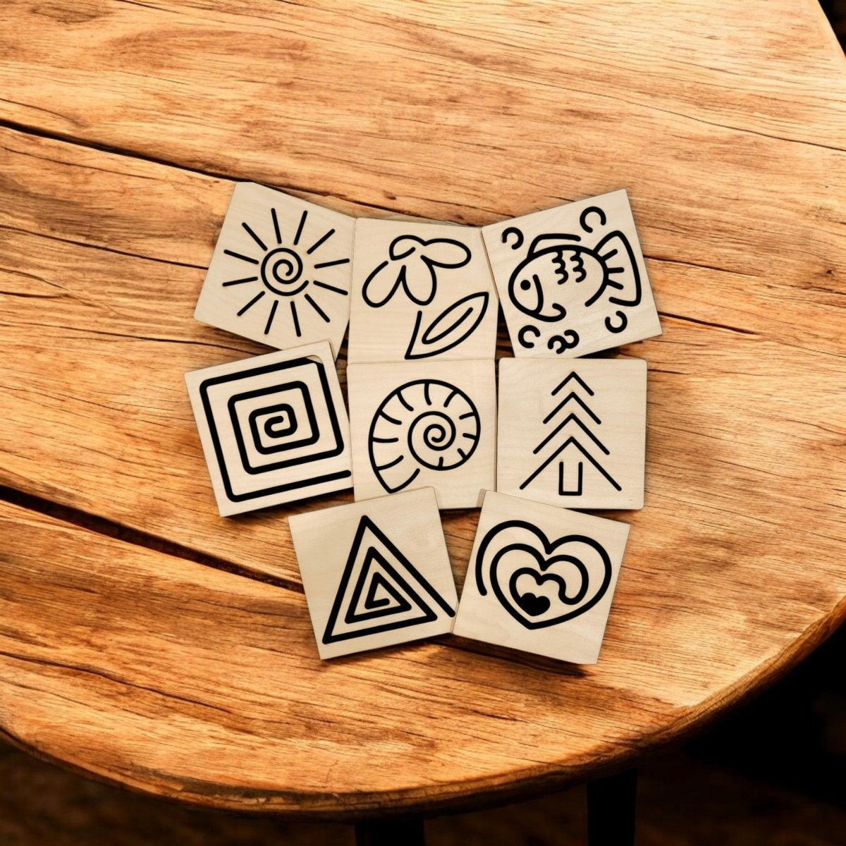 The Mirabilia Boutique Montessori Style Tracing Boards Set of 8 features wooden boards with black designs—a sun, flower, fish, spiral, leaf, tree, triangle, and heart—ideal for developing fine motor control and pre-writing skills.