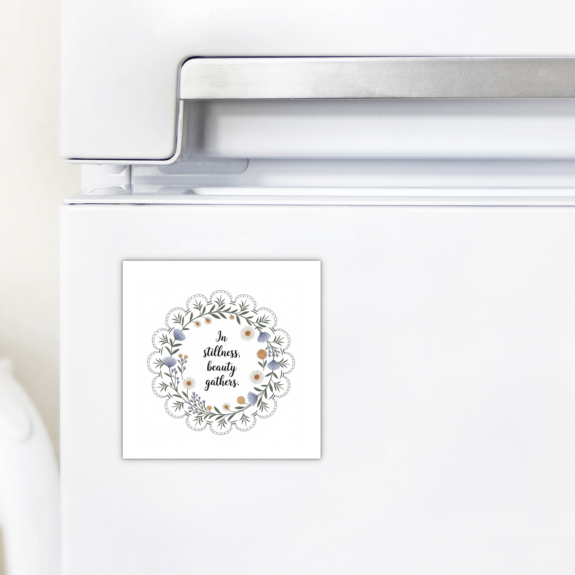 The In Stillness Beauty Gathers Floral Quote Magnet by Mirabilia Boutique features a wreath and the phrase “In stillness, beauty gathers”—an inspirational accent ideal for mindful home decor.