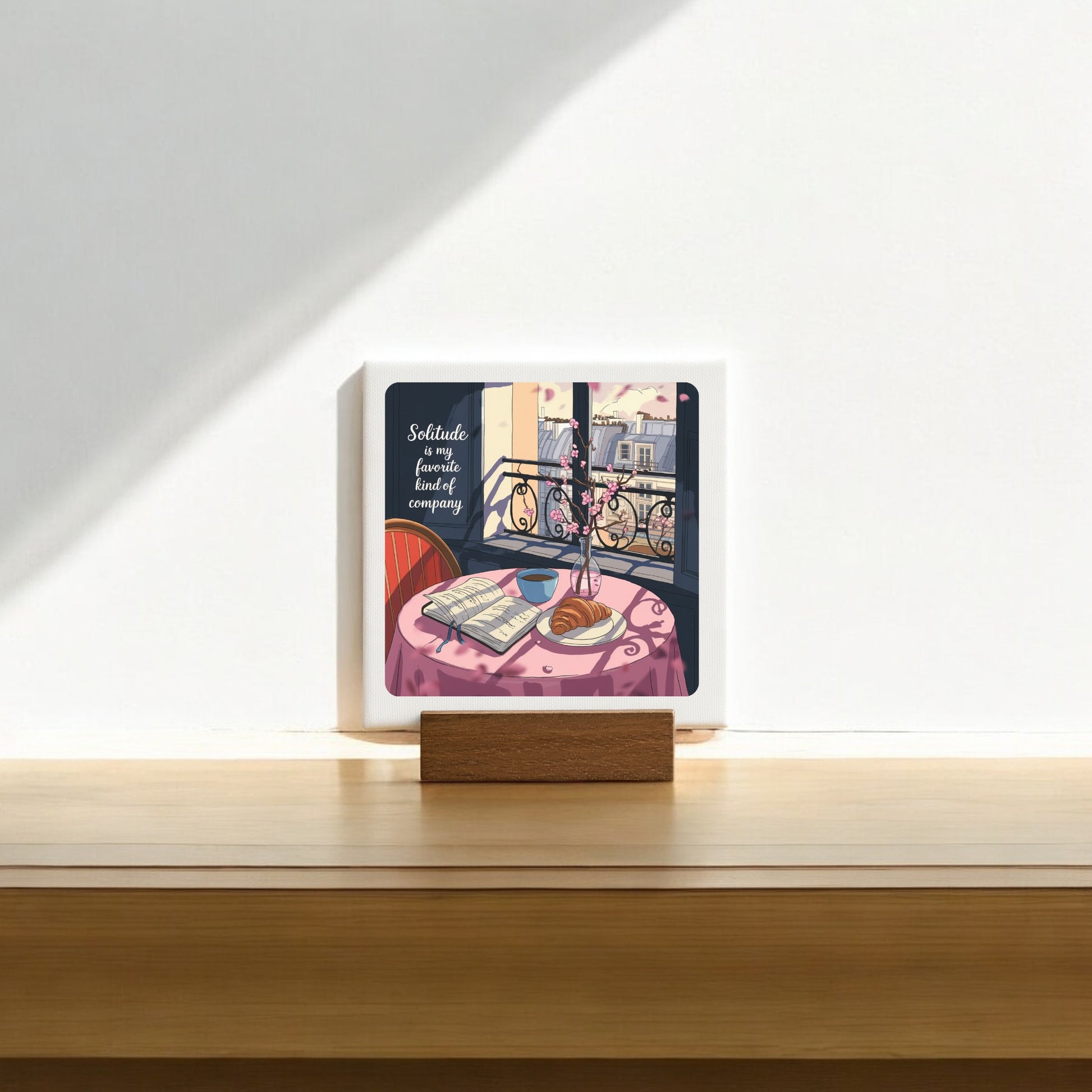 The Solitude Mini Sign – Parisian Morning Still Life by Mirabilia Boutique features a cozy table scene and the quote, "Solitude is a fine, lovely, beautiful company"—a thoughtful gift for introverts.