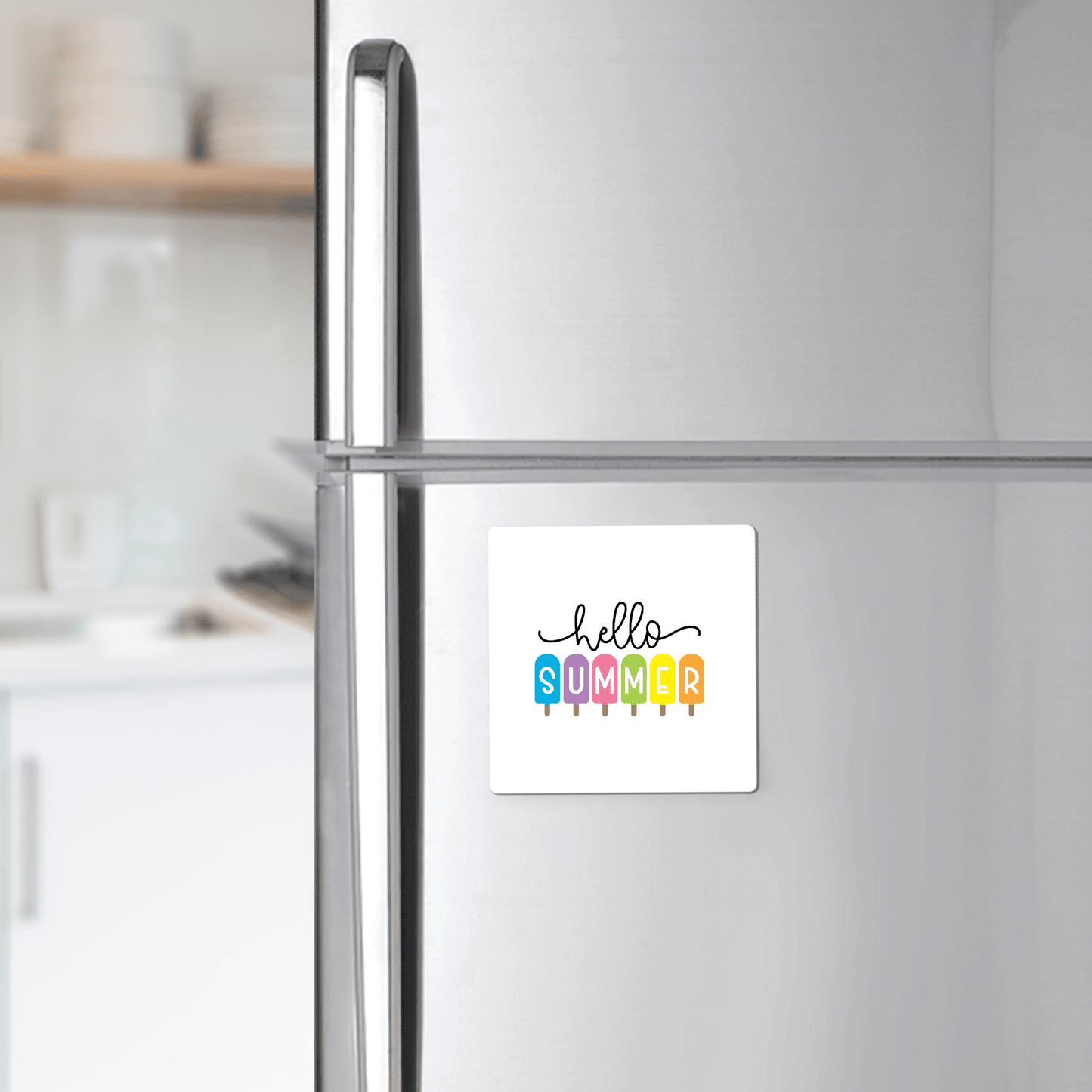 The Hello Summer Popsicle Magnet – Rainbow Ice Pop Fridge Art by Mirabilia Boutique brings a cheerful touch to the silver refrigerator.