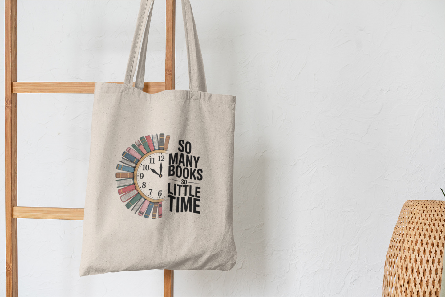 The So Many Books Canvas Tote Bag by Mirabilia Boutique hangs on a wooden rack. This beige tote features a clock with books as numbers and the phrase "SO MANY BOOKS SO LITTLE TIME"—a perfect gift for book lovers.
