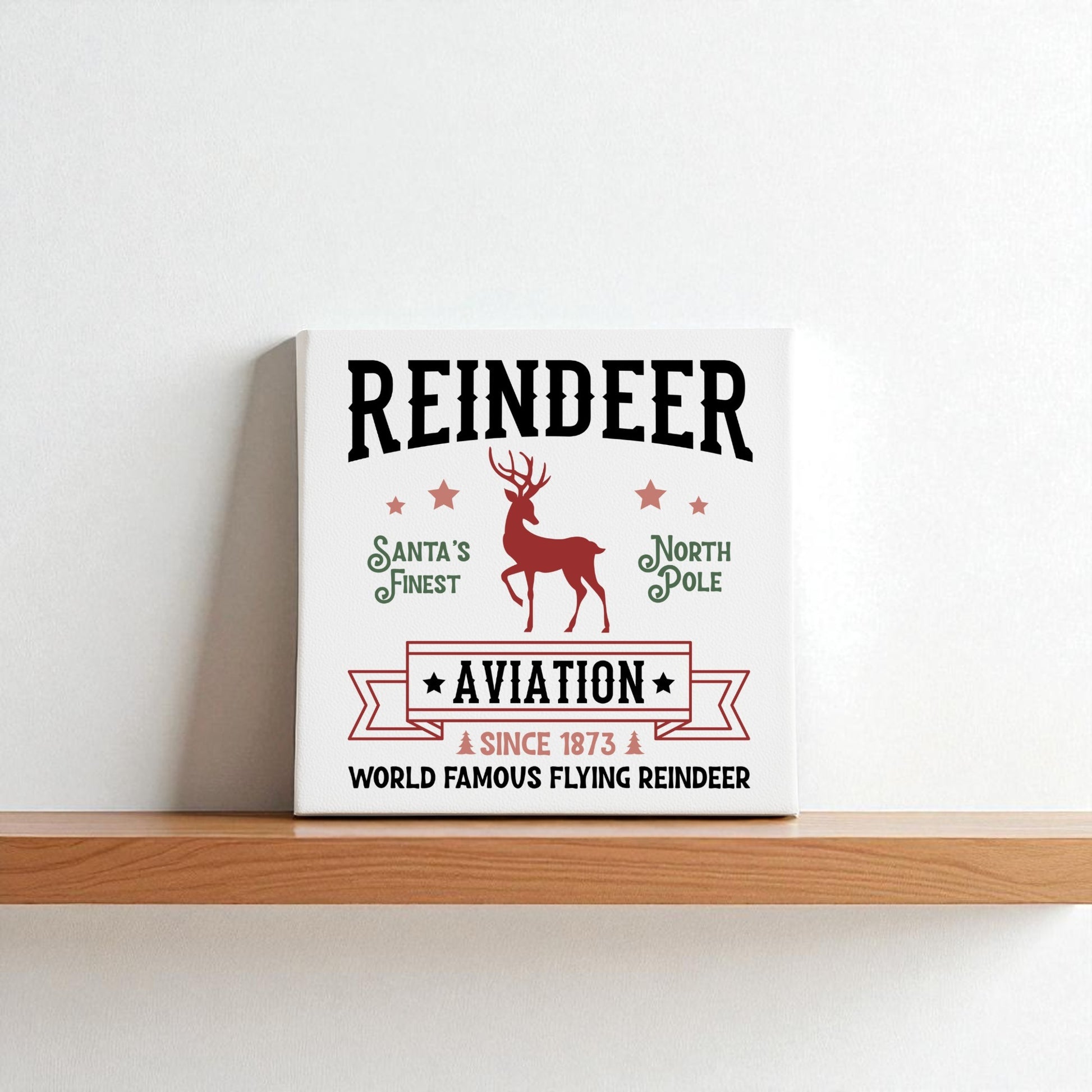 The Reindeer Aviation Christmas Sign by Mirabilia Boutique features a vintage North Pole design with reindeer art and festive text on canvas—perfect holiday decor for your home.