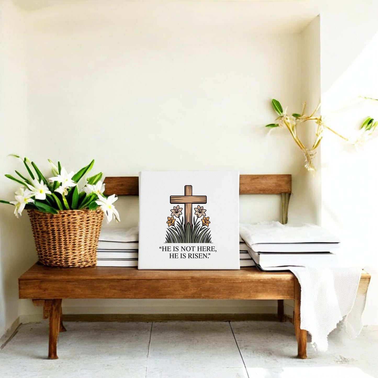 A wooden bench with white cushions displays a basket of lilies and the Mirabilia Boutique He Is Risen Cross & Lily Canvas – 8x8 Easter Art, featuring a floral cross and "He is not here, He is risen," with Easter decor and a plant nearby.