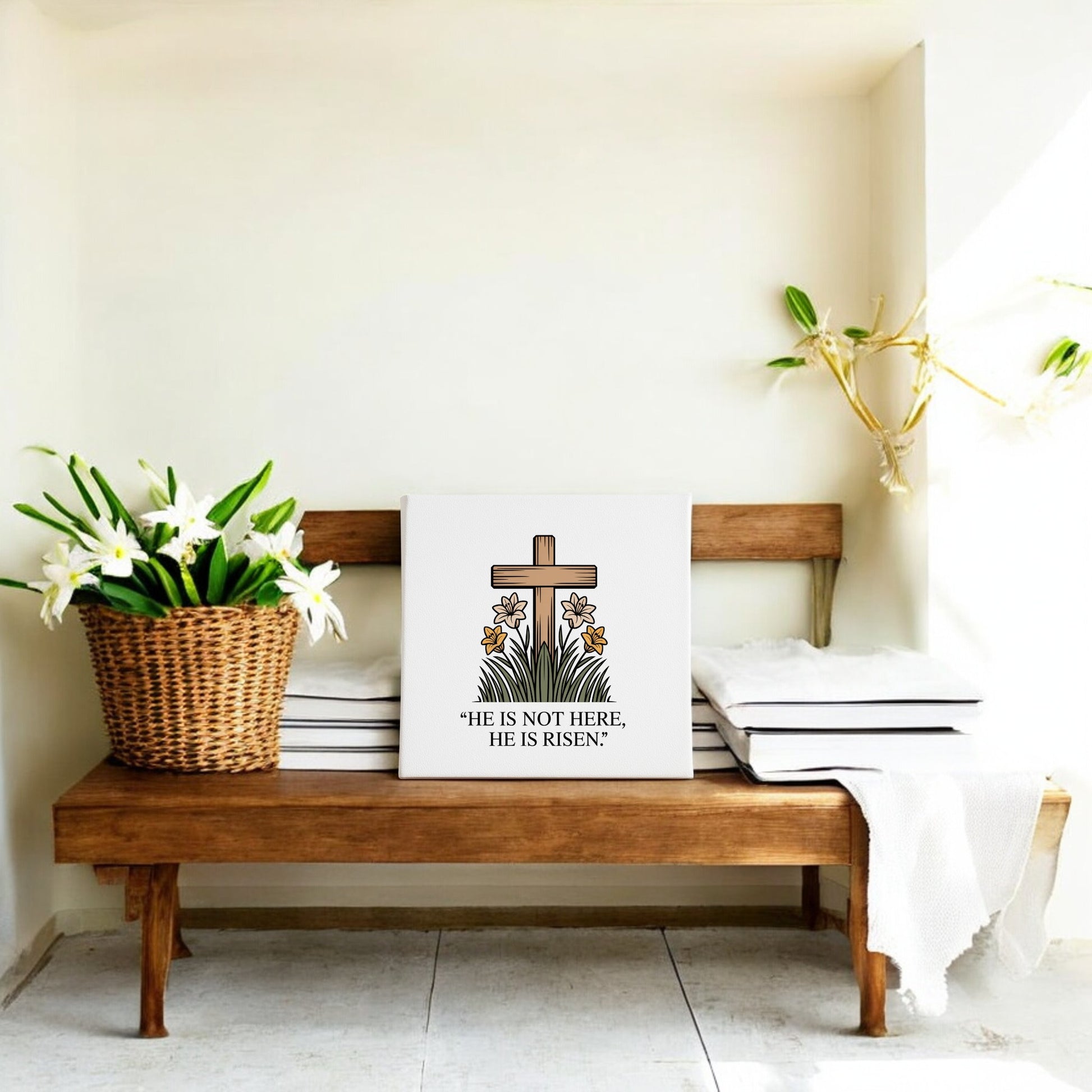A wooden bench with white cushions displays a basket of lilies and the Mirabilia Boutique He Is Risen Cross & Lily Canvas – 8x8 Easter Art, featuring a floral cross and "He is not here, He is risen," with Easter decor and a plant nearby.