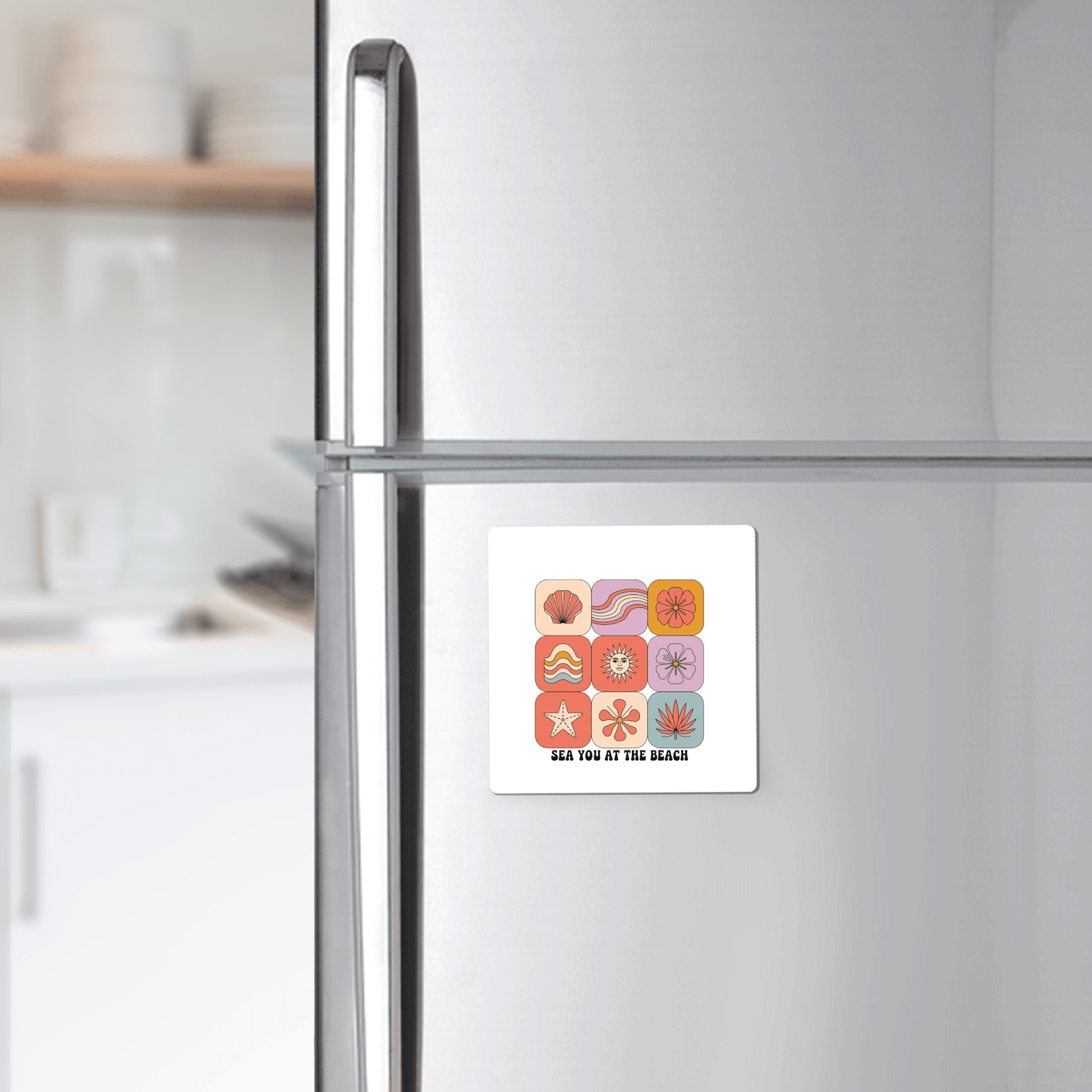 A refrigerator in a kitchen displays the Mirabilia Boutique "Sea You at the Beach Magnet – Retro Summer Vibes," a square magnet with colorful beach icons and the phrase "SEA YOU AT THE BEACH," adding coastal decor flair.