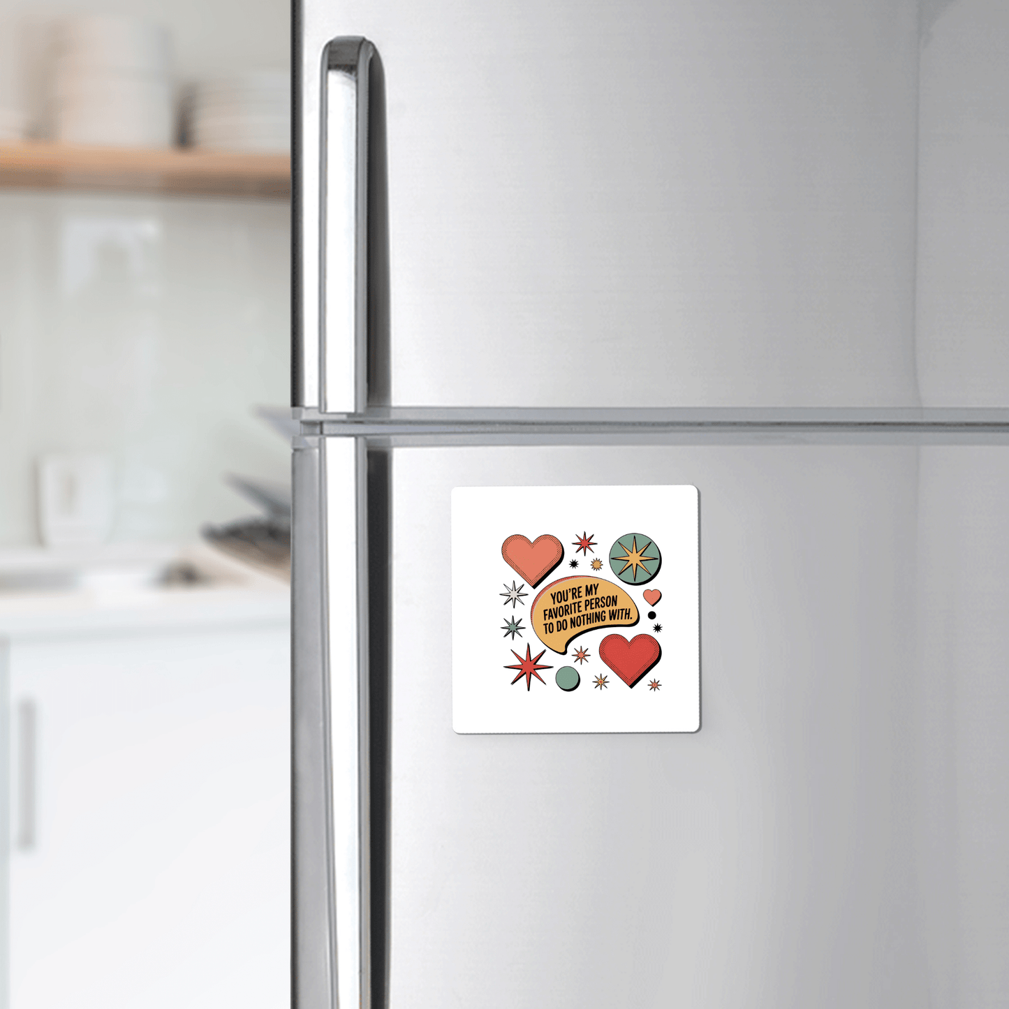 A silver fridge displays the Mirabilia Boutique Retro Love Quote Magnet, featuring red hearts, a lemon slice, and starbursts with the quote “You’ve got to have passion to do anything with it,” in a modern kitchen.