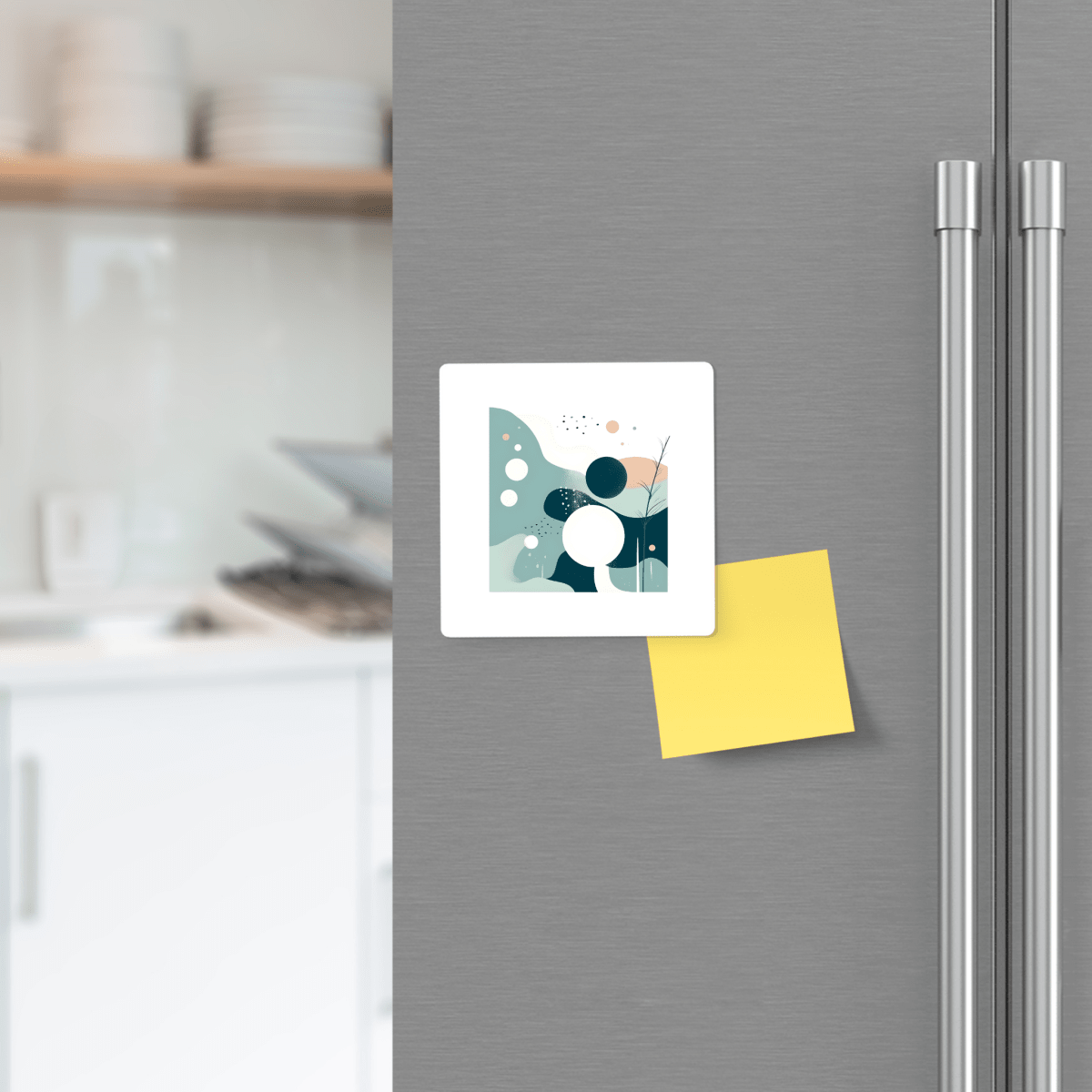 A Quiet Tides Mid Century Modern Magnet by Mirabilia Boutique in teal ocean blue and a yellow sticky note are attached to a stainless steel refrigerator door in a modern kitchen, with blurred shelves and dishes in the background.