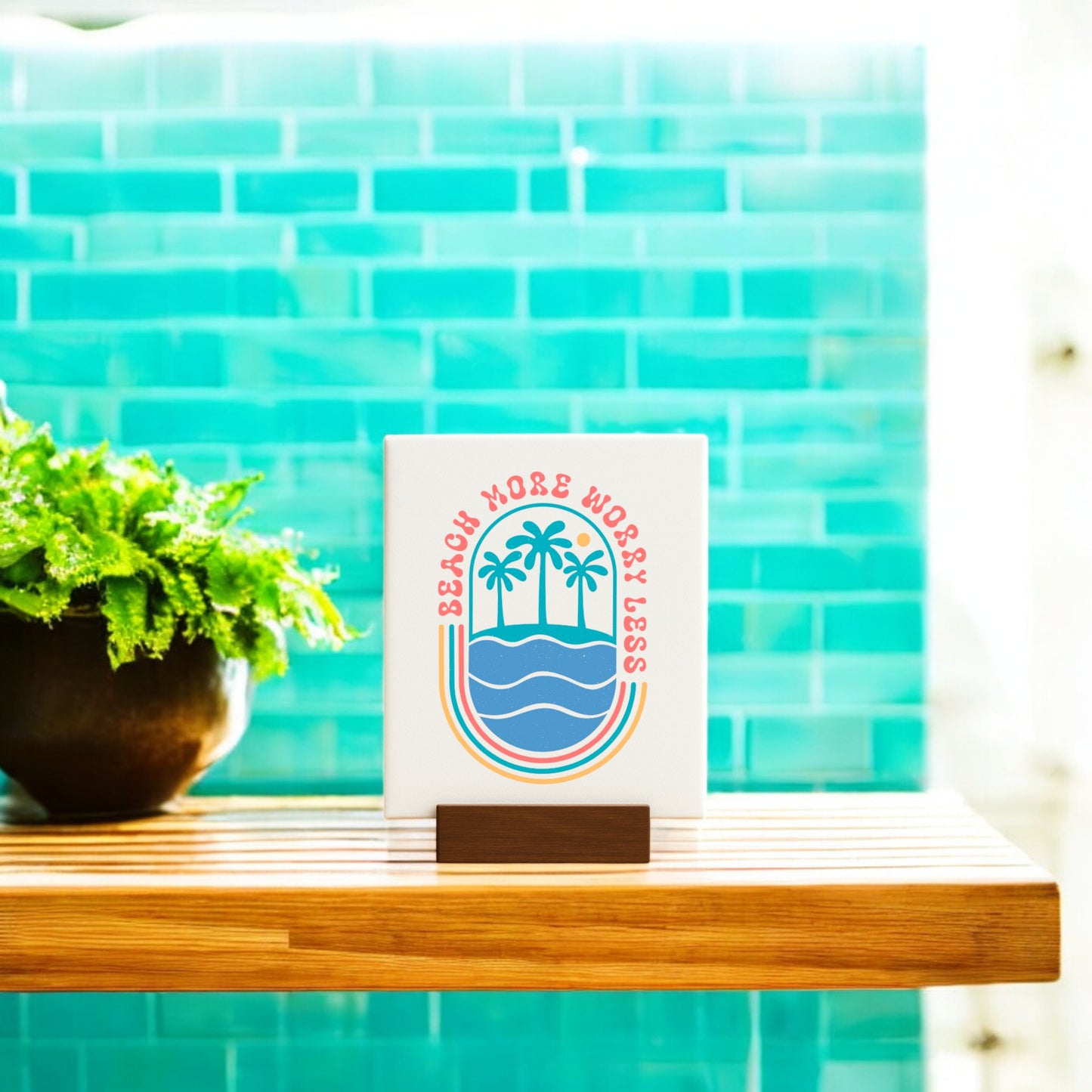 The Mirabilia Boutique Beach More Worry Less Retro Summer Sign features a beach and palm tree graphic, perfect as summer decor or a gift. It adds coastal charm beside plants or turquoise tiles.