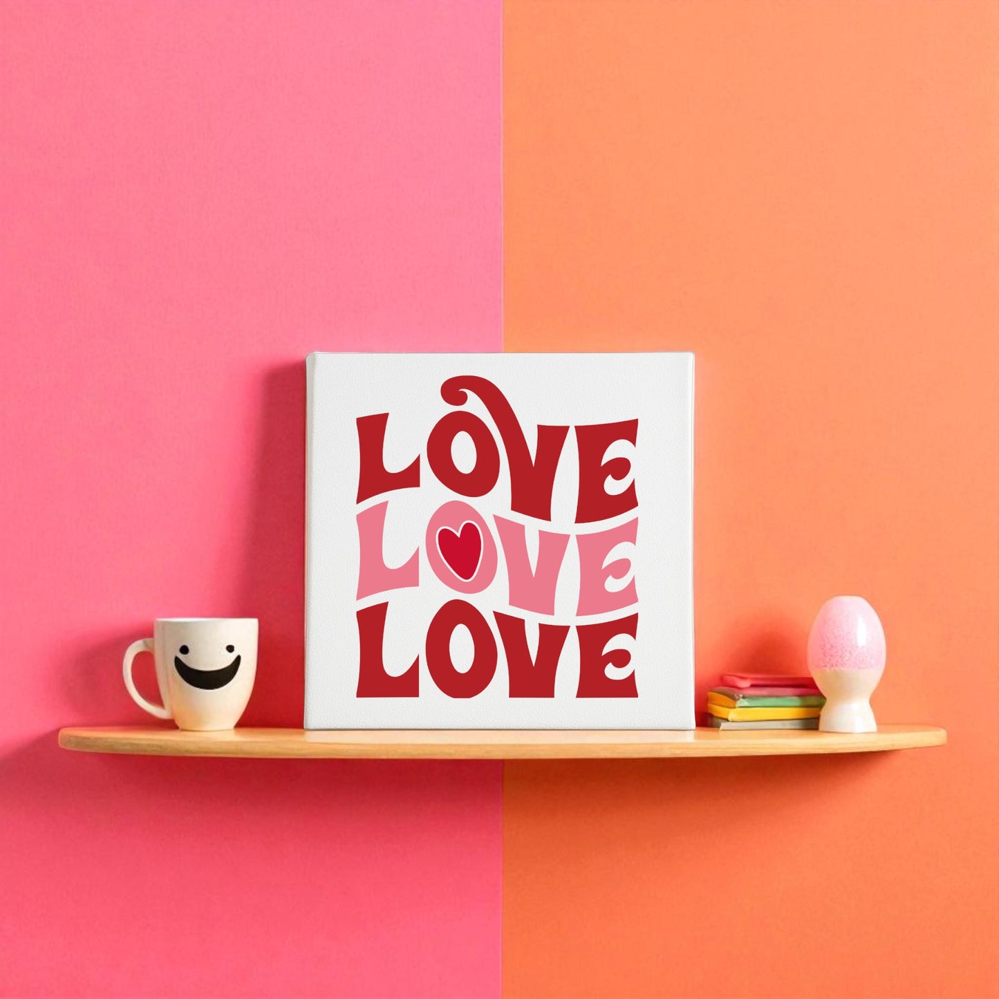 A wall shelf styled with a smiley face mug, vibrant coasters, an egg-shaped accent, and the Retro LOVE Canvas by Mirabilia Boutique—groovy Valentine’s decor with bold “LOVE LOVE LOVE” text and a playful pink-orange background.