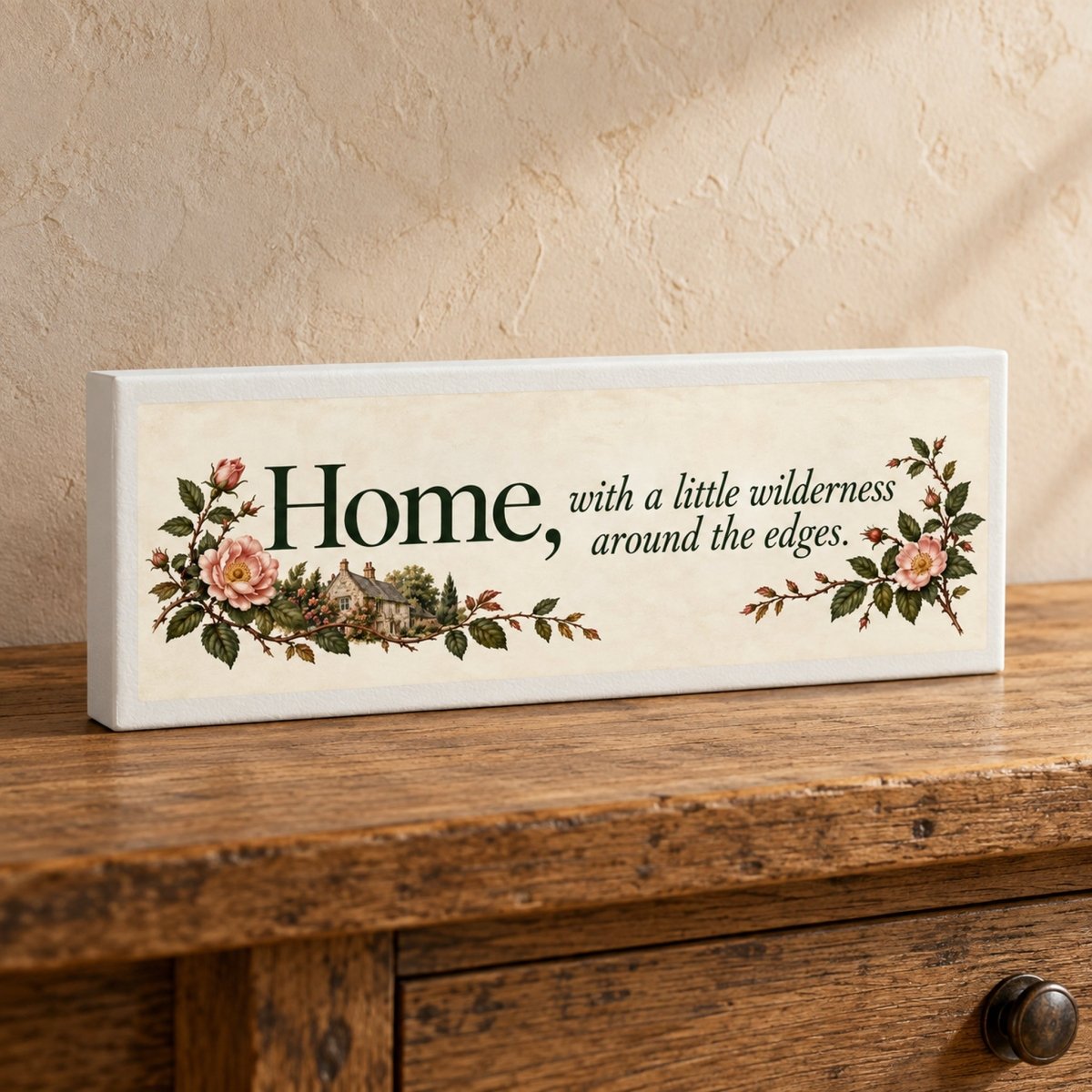 Home & Wilderness Canvas Shelf Sitter by Mirabilia Boutique, a rectangular sign reading “Home, with a little wilderness around the edges,” decorated with illustrations of an English stone cottage, roses, and greenery.