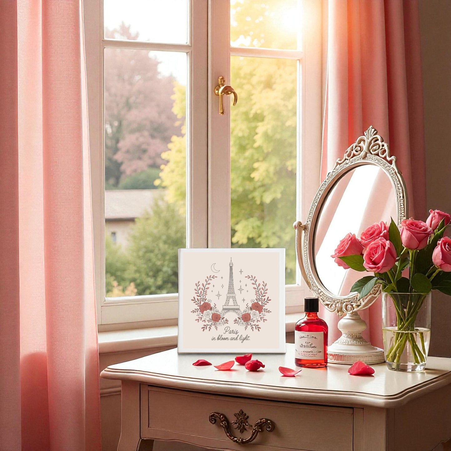 A white vanity with a round mirror, pink roses, perfume, and Mirabilia Boutique’s Paris in Bloom and Light Canvas – Rosy Eiffel Tower Art sits by a window with pink curtains—a dreamy touch for romantic home decor.