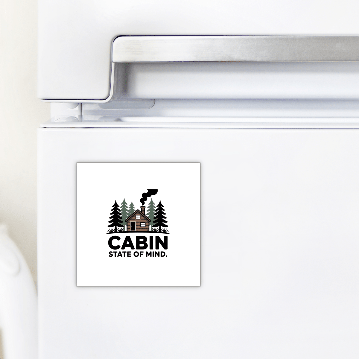 The Cabin State of Mind Magnet by Mirabilia Boutique features a cozy cabin illustration with pine trees and smoke, plus “CABIN STATE OF MIND” text—perfect rustic cabin decor for your fridge or woodland-inspired home.