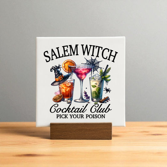 The Salem Witch Cocktail Club Mini Sign by Mirabilia Boutique is a square Halloween bar decor piece on a wooden stand, featuring three colorful spooky cocktails and the phrase "Pick Your Poison" on a light gray background.