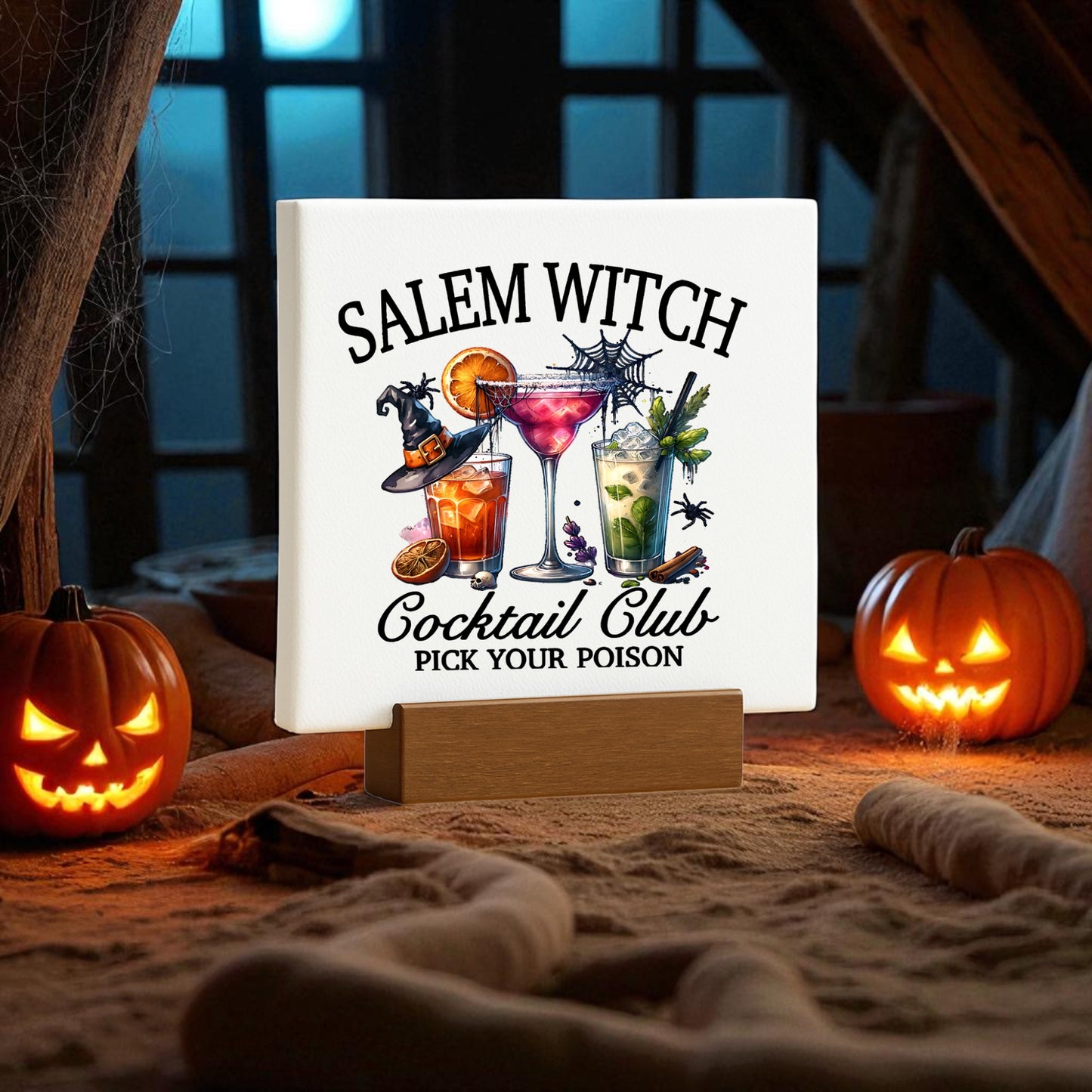The Mirabilia Boutique Salem Witch Cocktail Club Mini Sign features "Salem Witch Cocktail Club, Pick Your Poison" with cocktail illustrations, accented by two glowing jack-o'-lanterns—perfect Halloween bar decor for cozy spaces.