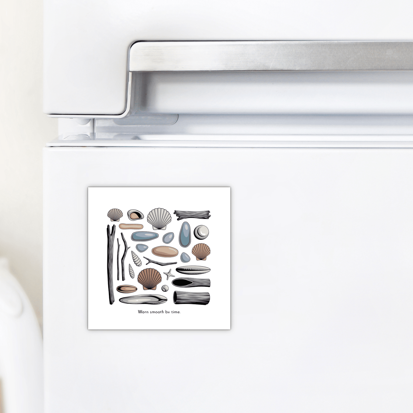 The Mirabilia Boutique "Worn Smooth by Time Magnet – Coastal Driftwood & Shell Art" features seashells, pebbles, driftwood, sea glass decor, and a starfish, shown here on a white refrigerator.