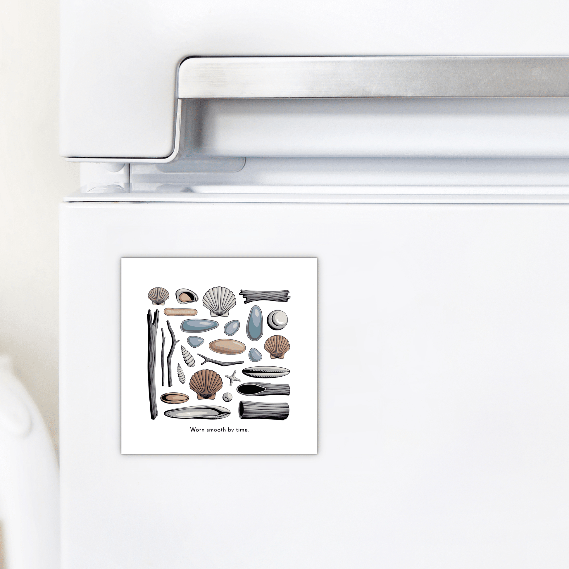 The Mirabilia Boutique "Worn Smooth by Time Magnet – Coastal Driftwood & Shell Art" features seashells, pebbles, driftwood, sea glass decor, and a starfish, shown here on a white refrigerator.