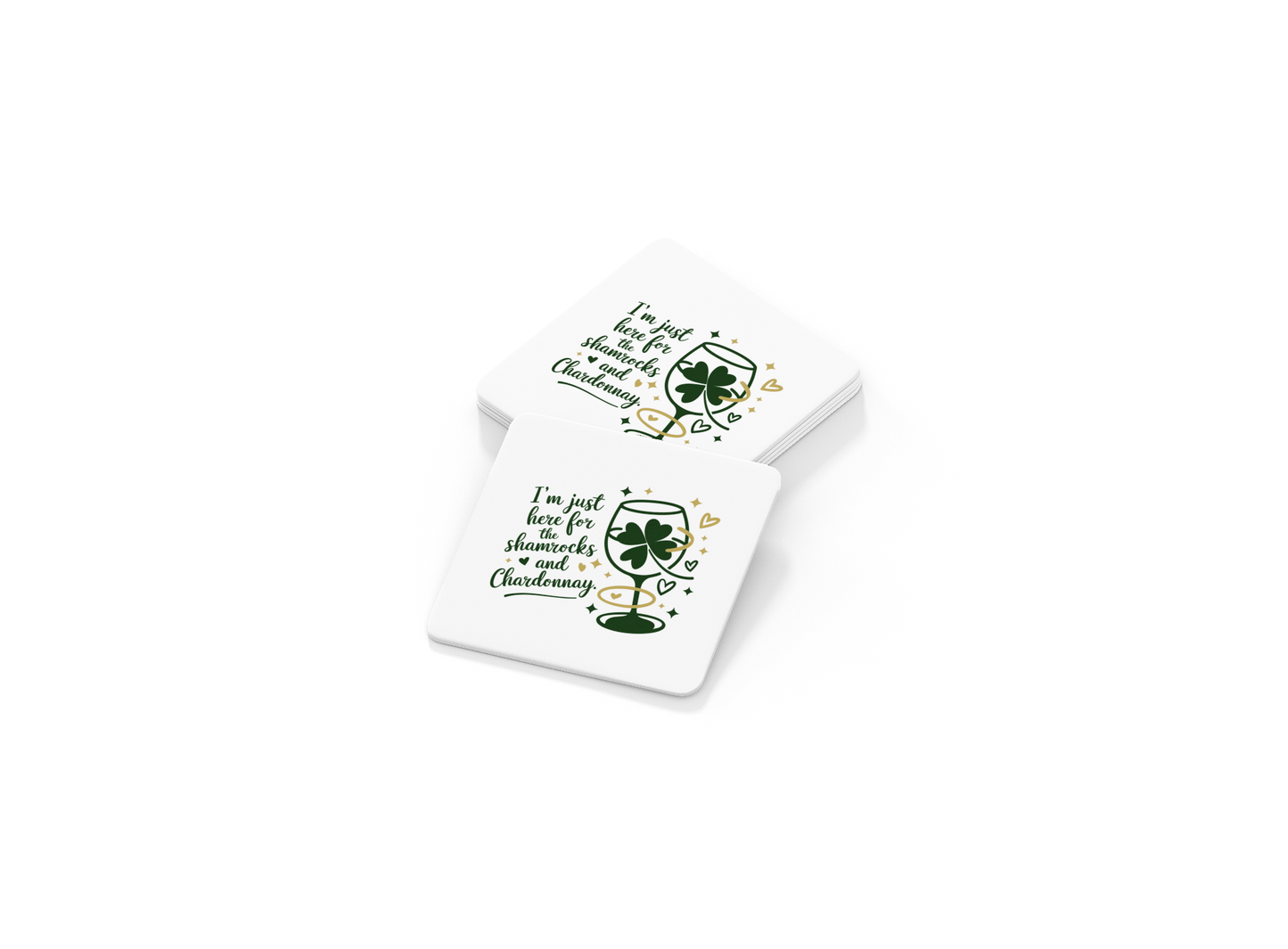 The Shamrocks and Chardonnay Coaster Set by Mirabilia Boutique includes two white St. Patrick’s Day coasters with wine glass, shamrocks, hearts, and the phrase "I'm just here for shenanigans and Chardonnay." Great for wine lovers!.
