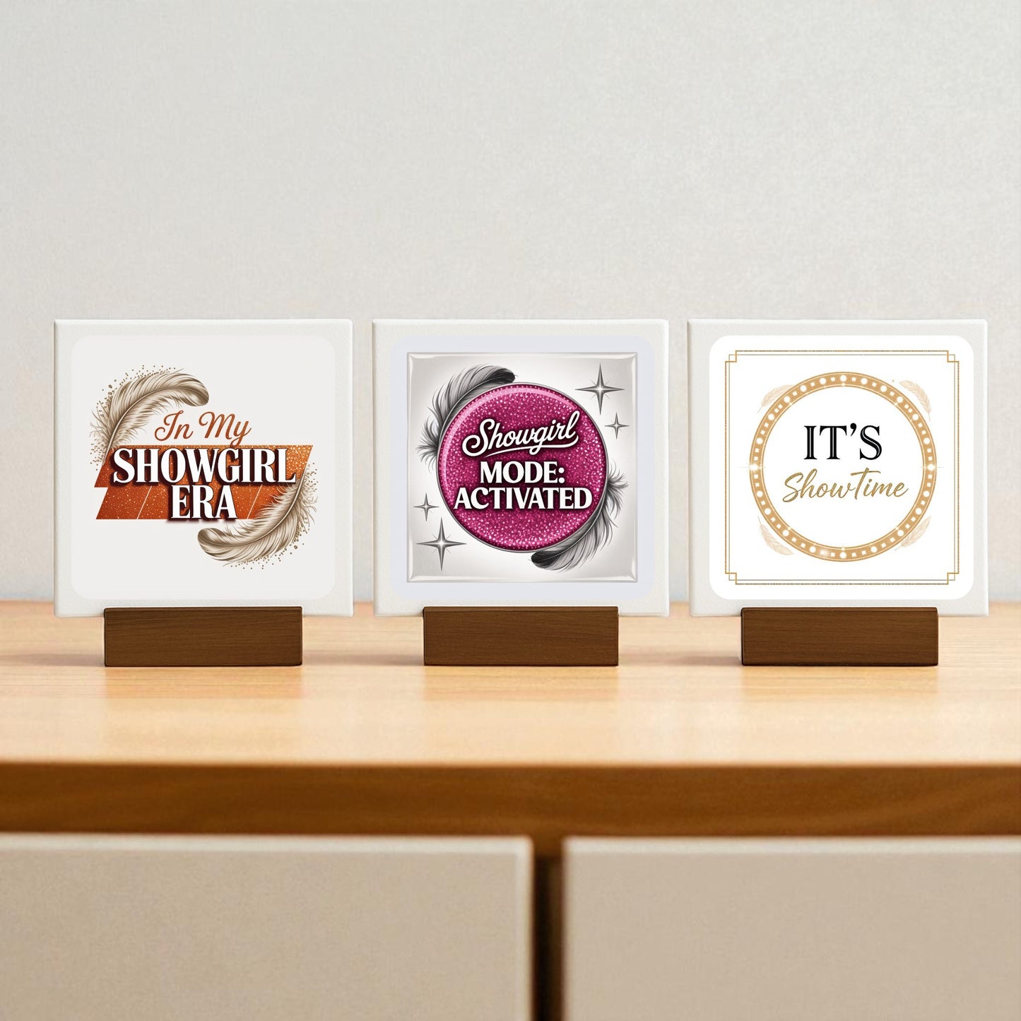 The Showgirl Mini Sign Trio by Mirabilia Boutique features three glam square signs—"In My Showgirl Era," "Showgirl Mode: Activated," and "IT'S Showtime"—with feather or sequin details. Perfect as gift or chic decor for desk and shelves.
