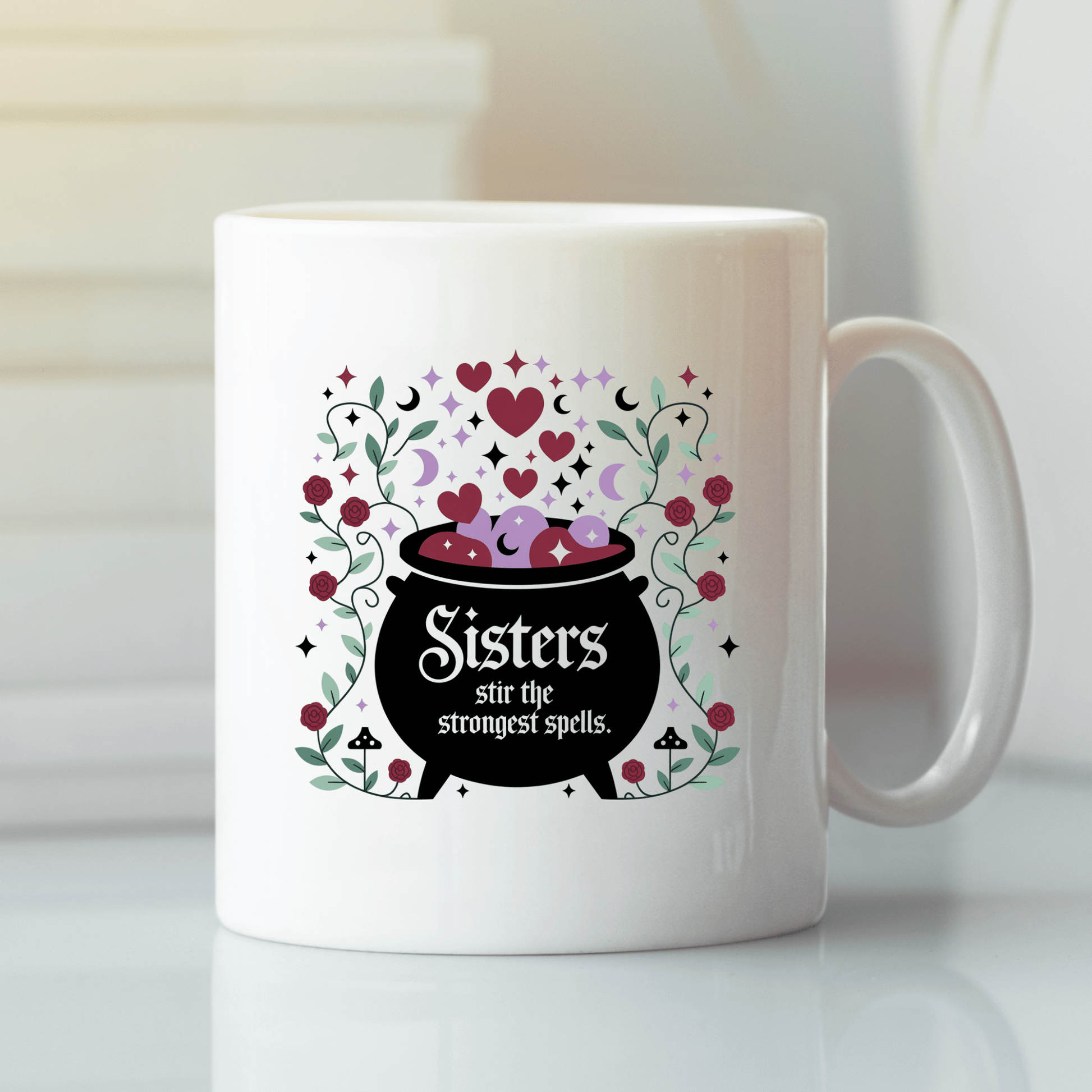 The Sisters Stir the Strongest Spells Mug by Mirabilia Boutique features a black cauldron with hearts, sparkles, and floral accents. Perfect witchy sister gift, its cauldron reads: "Sisters stir the strongest spells.
