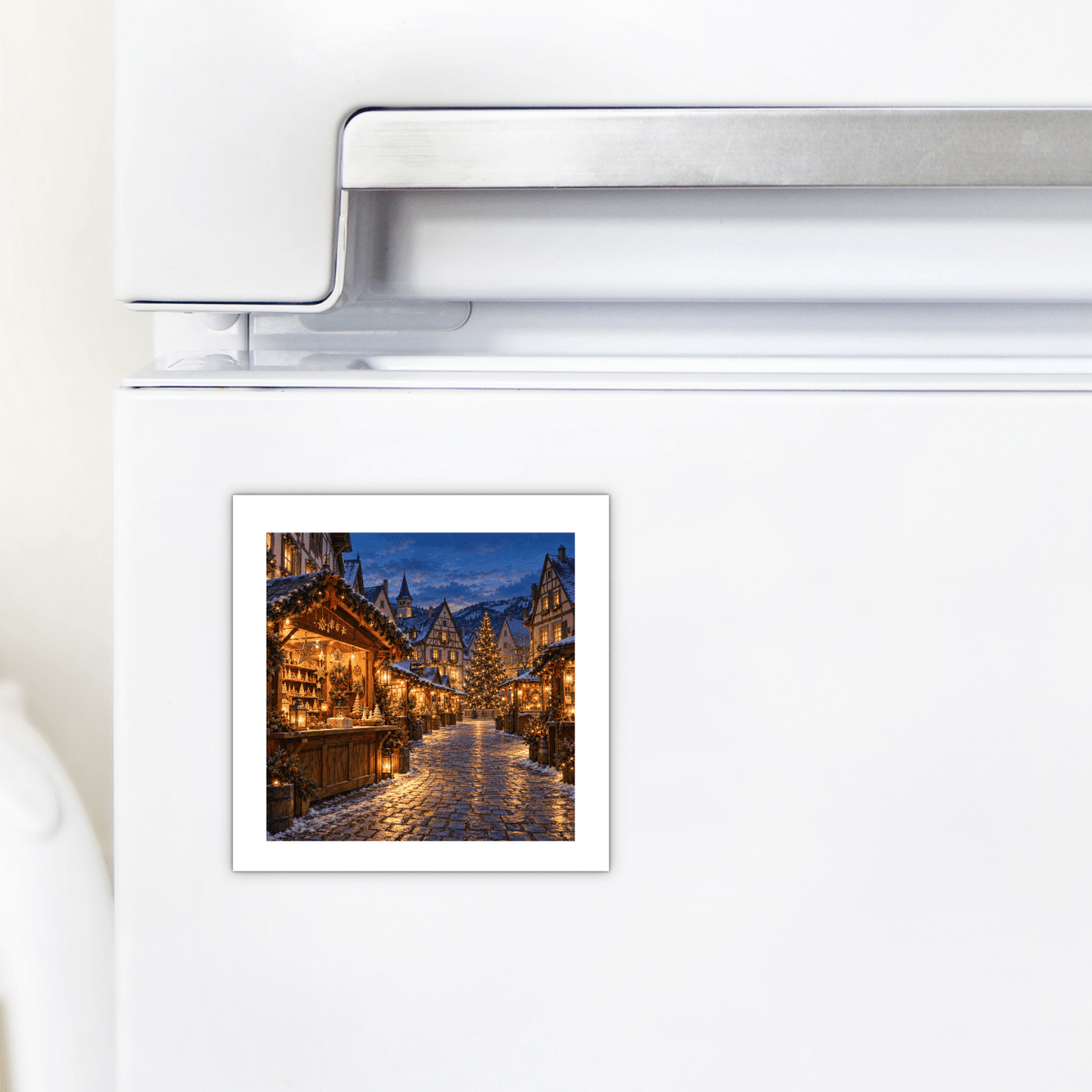 An Evening to Wander Magnet | German Christmas Market square magnet on a refrigerator door, depicting snow-covered wooden stalls and a glowing central tree at twilight.