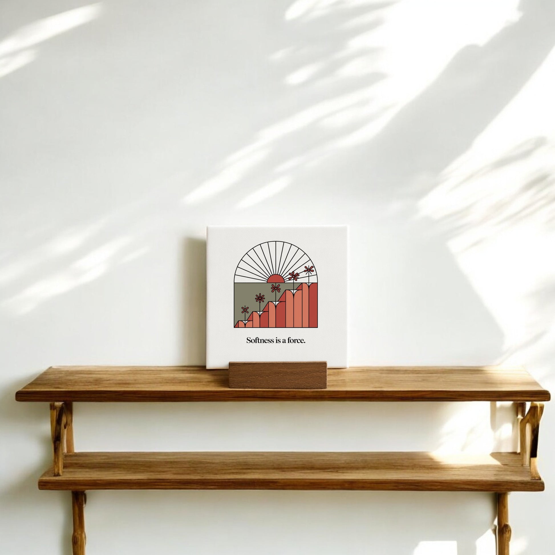 The Softness Is a Force Mini Canvas Sign by Mirabilia Boutique features a sun, mountains, and palm trees with the phrase “Softness is a force”—the perfect motivational desk decor for an inspiring, minimalist space.