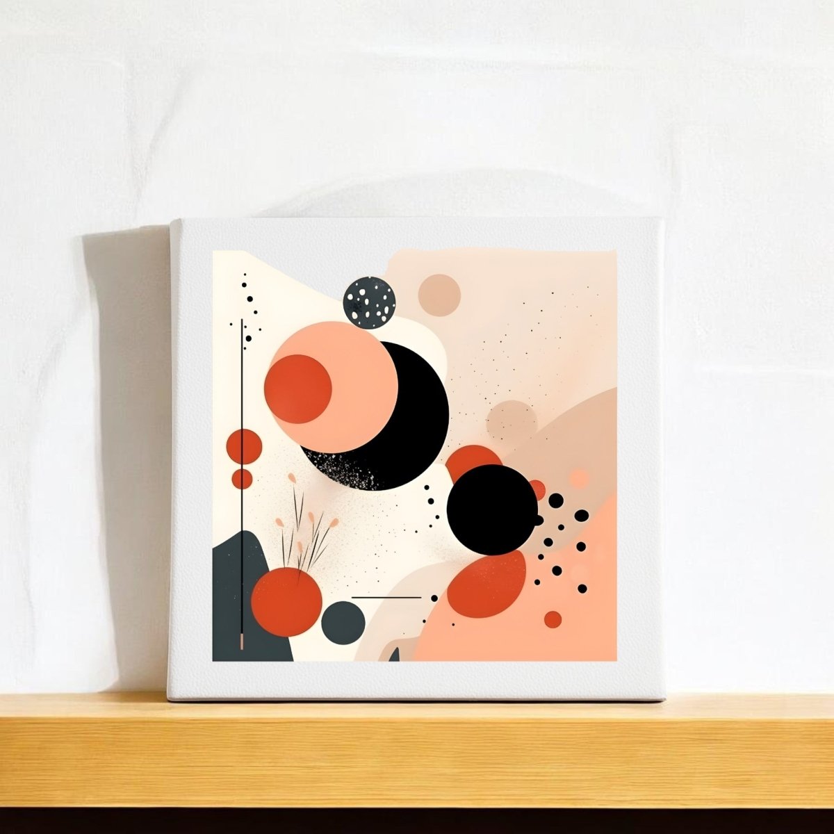 The Solar Bloom Mid Century Modern Canvas by Mirabilia Boutique showcases abstract overlapping circles in black, peach, and orange with minimalist dots and lines, displayed on a wooden shelf against a white textured wall.