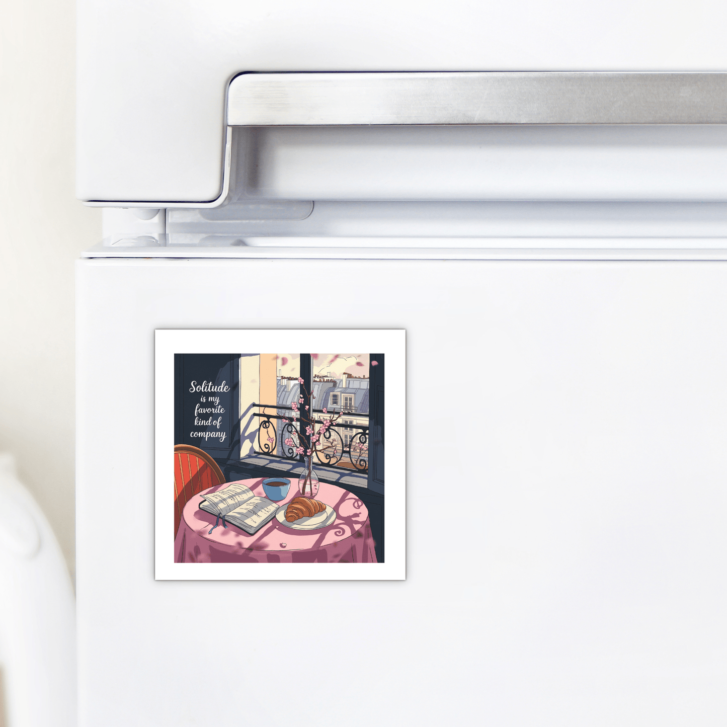 Decorate your fridge with Mirabilia Boutique’s Solitude Magnet – Paris Morning Still Life, featuring a tranquil balcony scene with a book, glasses, and flowers. The magnet reads: "Solitude is a fine, kindly company." A perfect touch of Parisian charm.