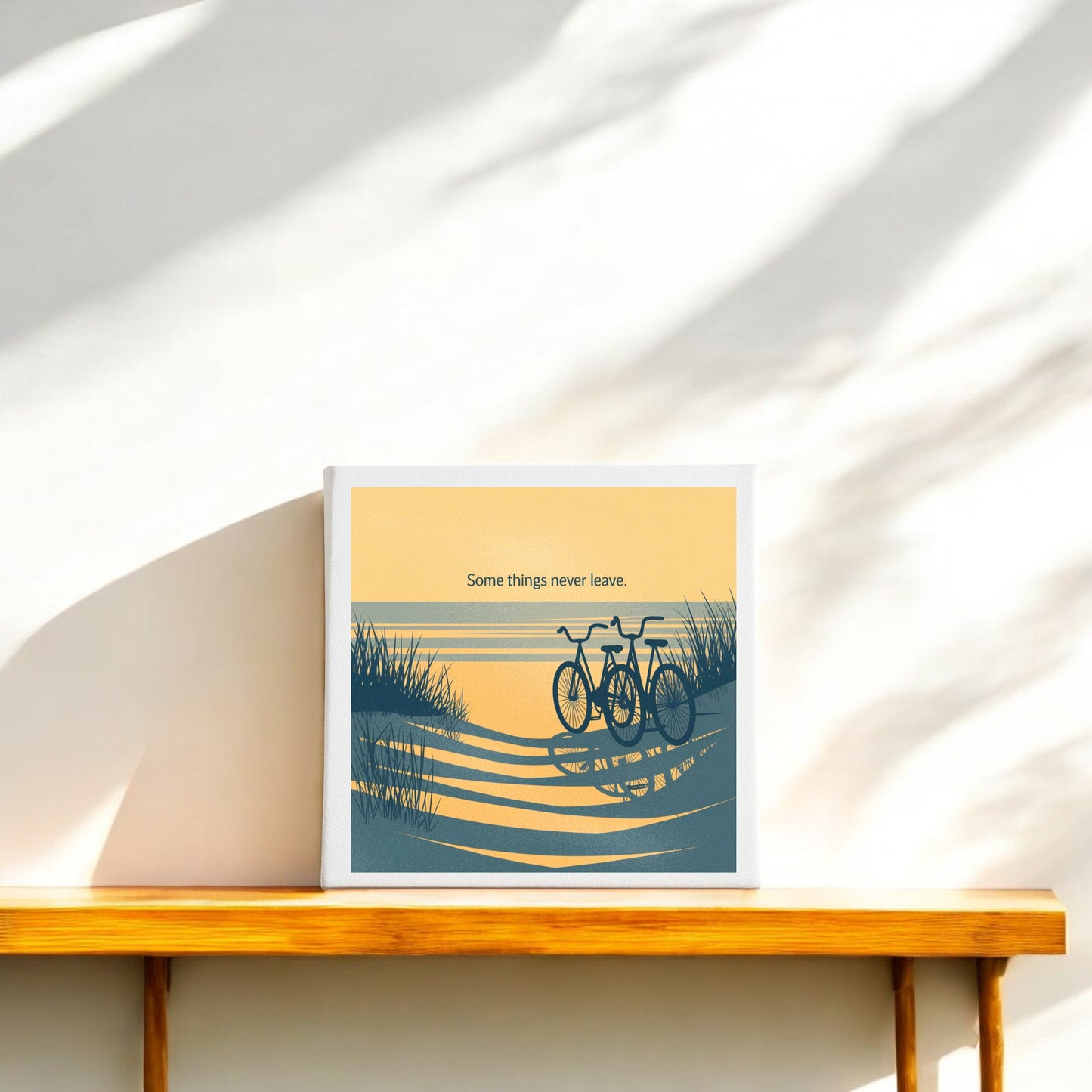 The "Some Things Never Leave Canvas – Coastal Memory Art" by Mirabilia Boutique features two bicycles by the water and tall grass under a yellow sky—sentimental coastal decor perfect for your shelf.