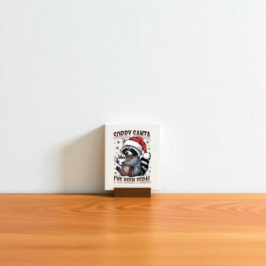The “Sorry Santa I’ve Been Feral” Sign by Mirabilia Boutique features a funny raccoon in holiday style—perfect for quirky Christmas decor or a hilarious Secret Santa gift.