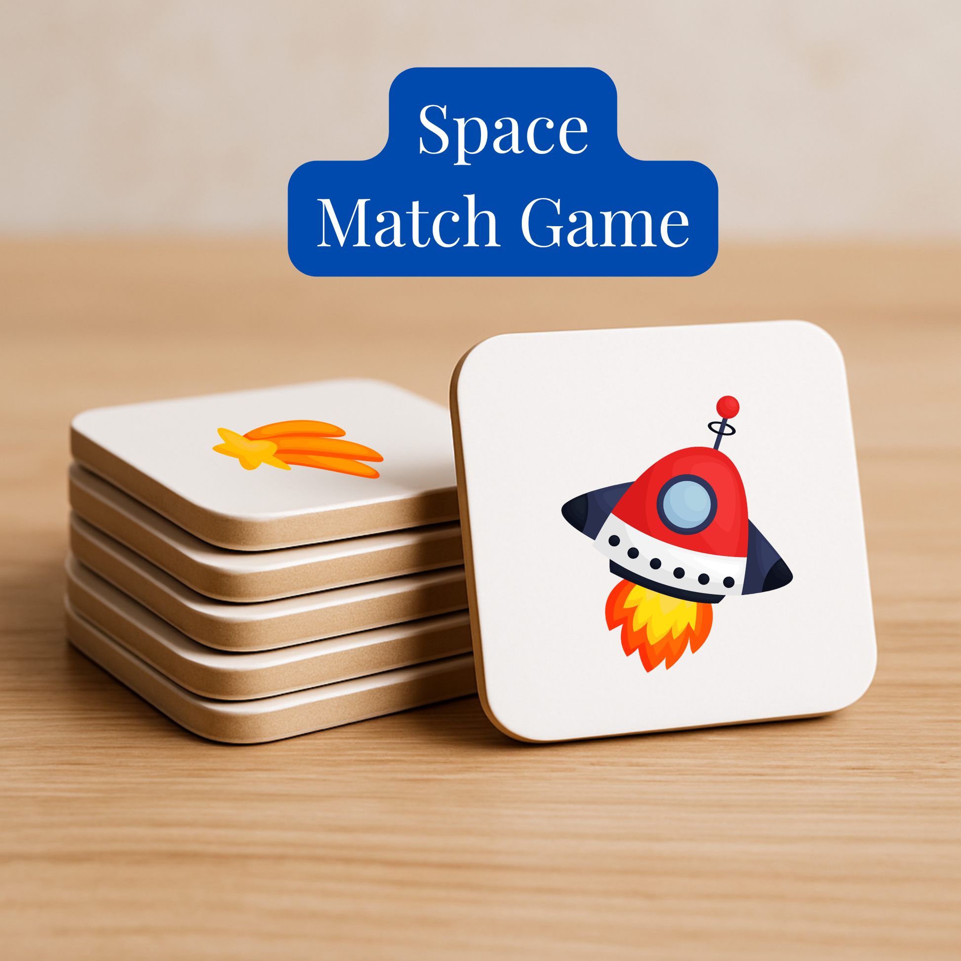 A stack of square cards from Mirabilia Boutique’s Space Match Game | Kids Memory Game (15 Matching Pairs) sits on wood; the top card shows a cartoon rocket, the next a shooting star, hinting at its fun space-themed memory gameplay.