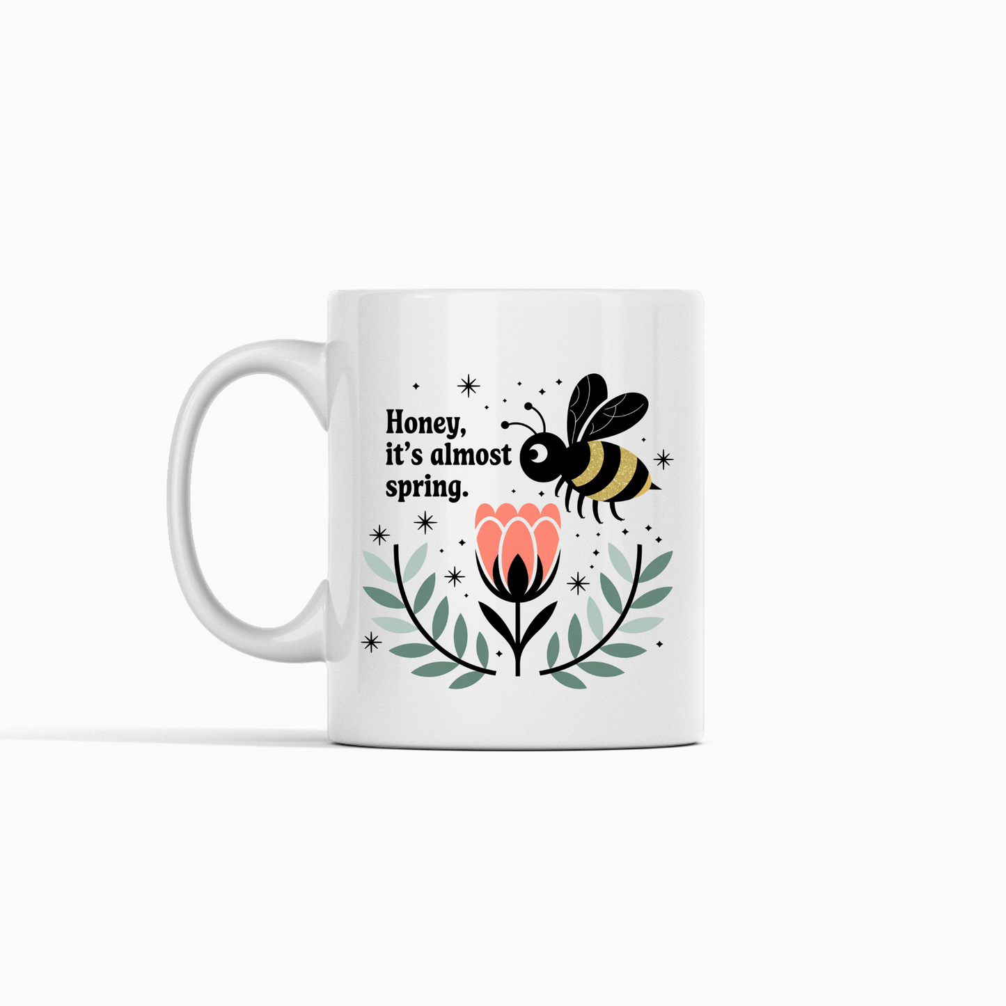 The Spring Bee Mug by Mirabilia Boutique features a bee above a pink flower with "Honey, it’s almost spring" text—perfect for welcoming spring with every sip.
