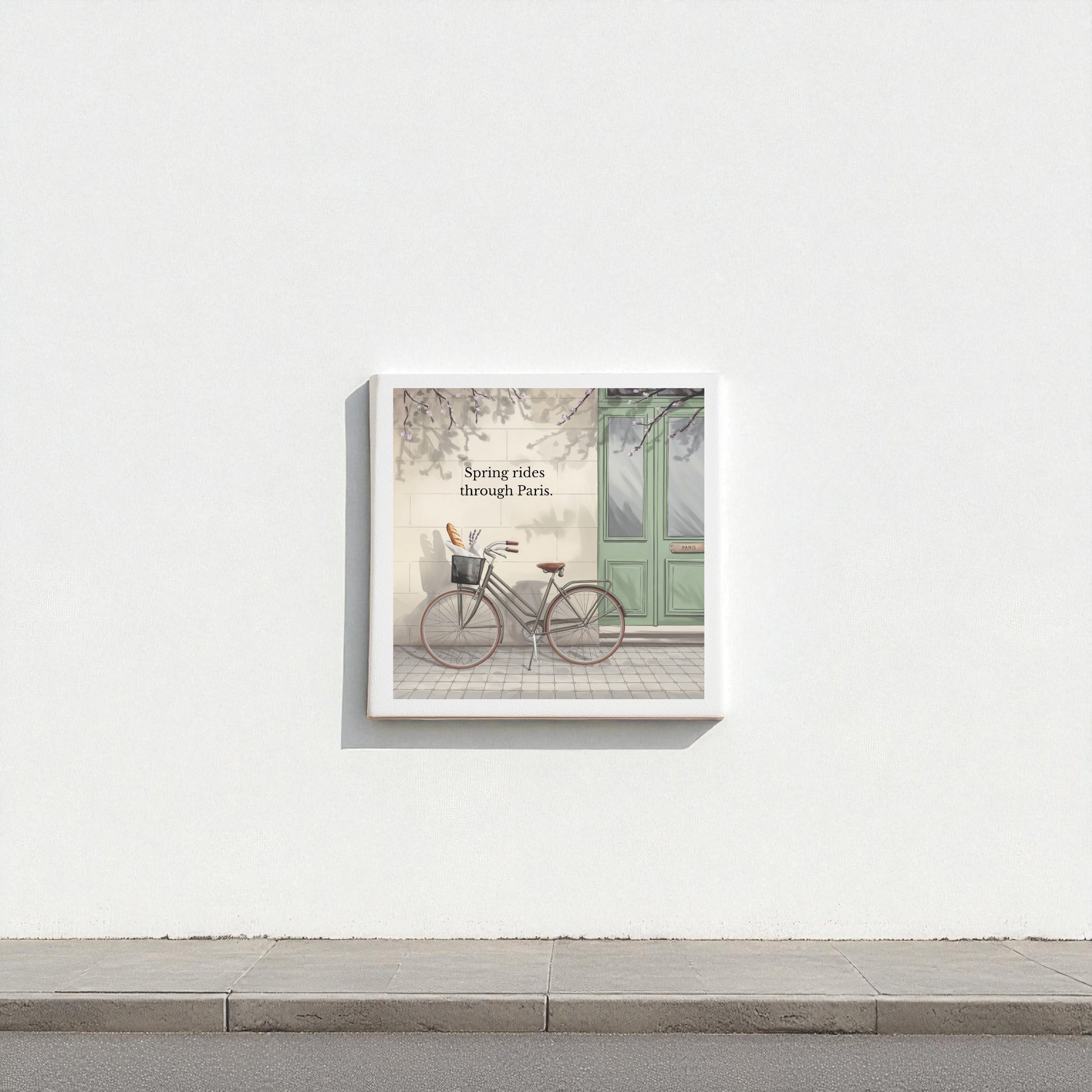 Mirabilia Boutique's "Spring Rides Through Paris Canvas Art" features a vintage bicycle by a green door, minimalist Paris scene, and the phrase “Spring rides through Paris”—ideal spring wall decor for any space.