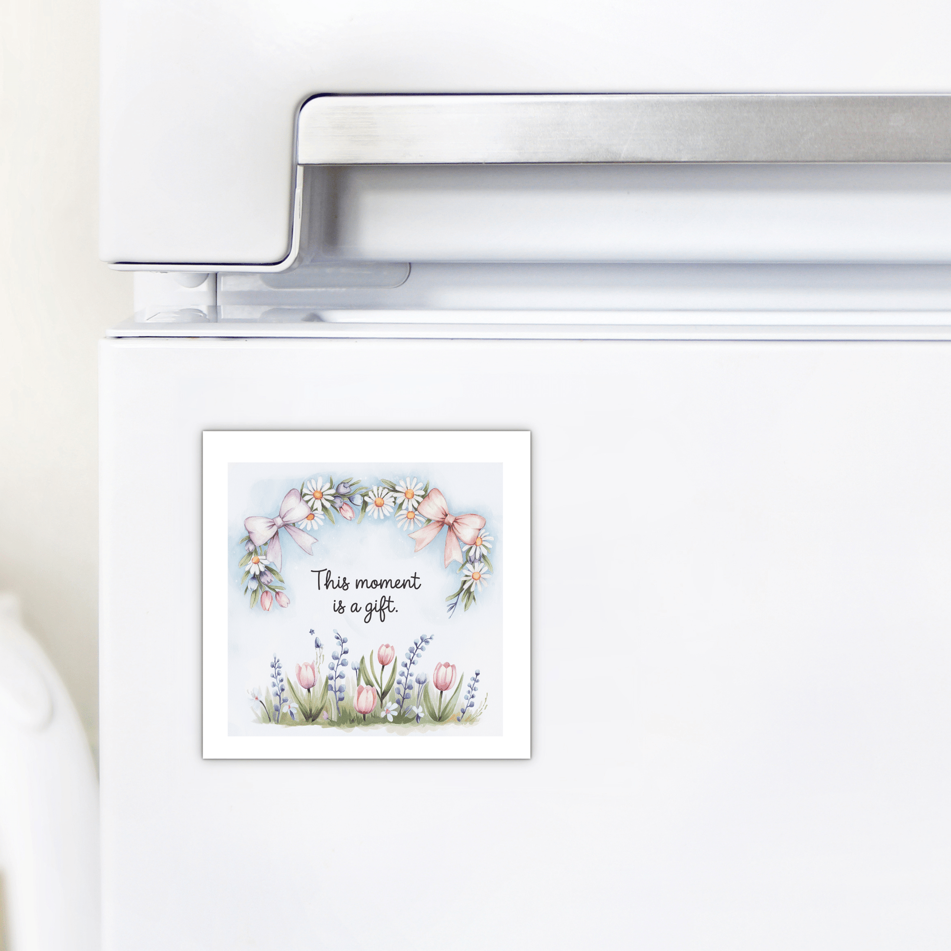 The Mirabilia Boutique “This Moment Is a Gift Magnet – Floral Spring Quote” features pastel daisies, tulips, lavender, and pink bows—an inspirational mindfulness gift for any home fridge.