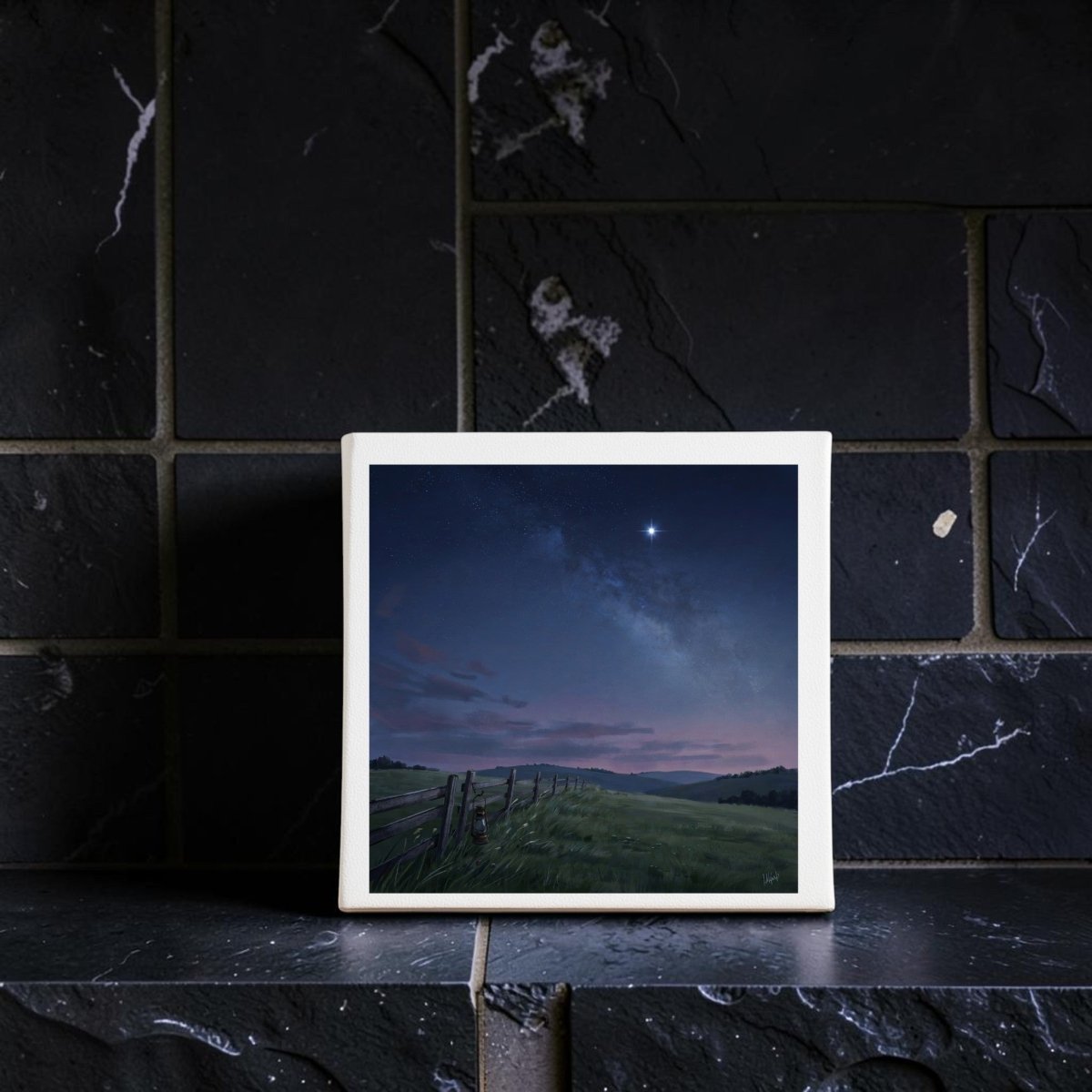 An 8x8 “Stay For The Stars” canvas by Mirabilia Boutique, featuring a serene starry night sky and grassy field, is displayed as calming landscape decor on a dark tiled surface against a matching, crackled tile wall.
